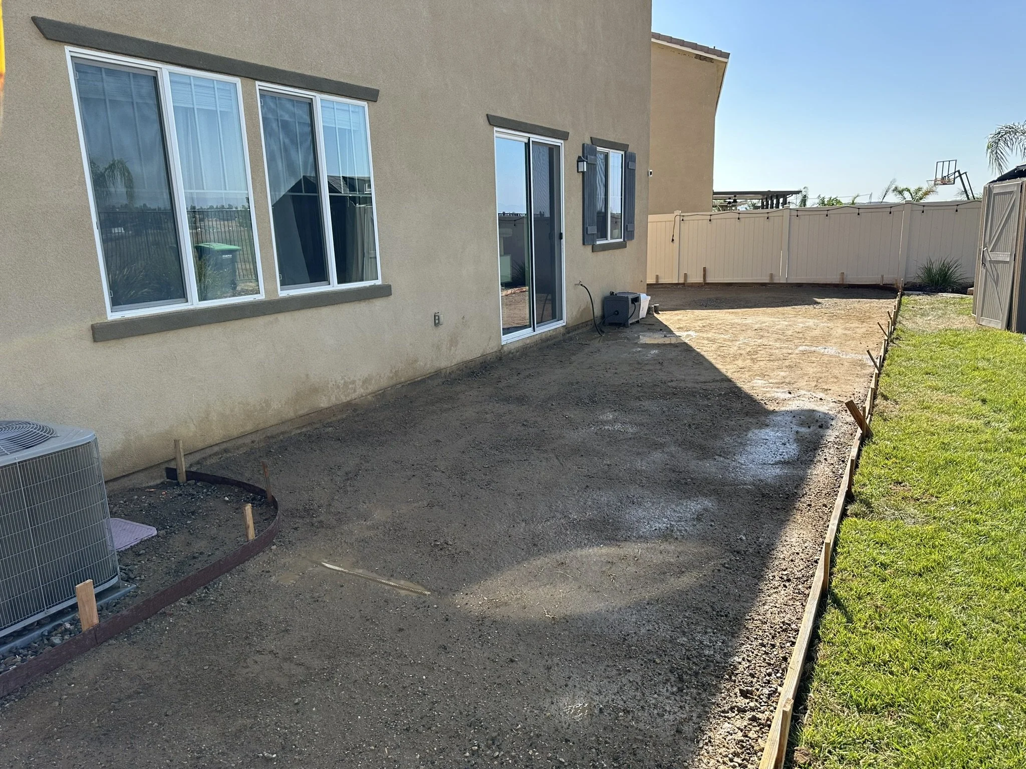 CONCRETE & FLATWORK | Before — prepared ground beside the home before the new concrete patio.