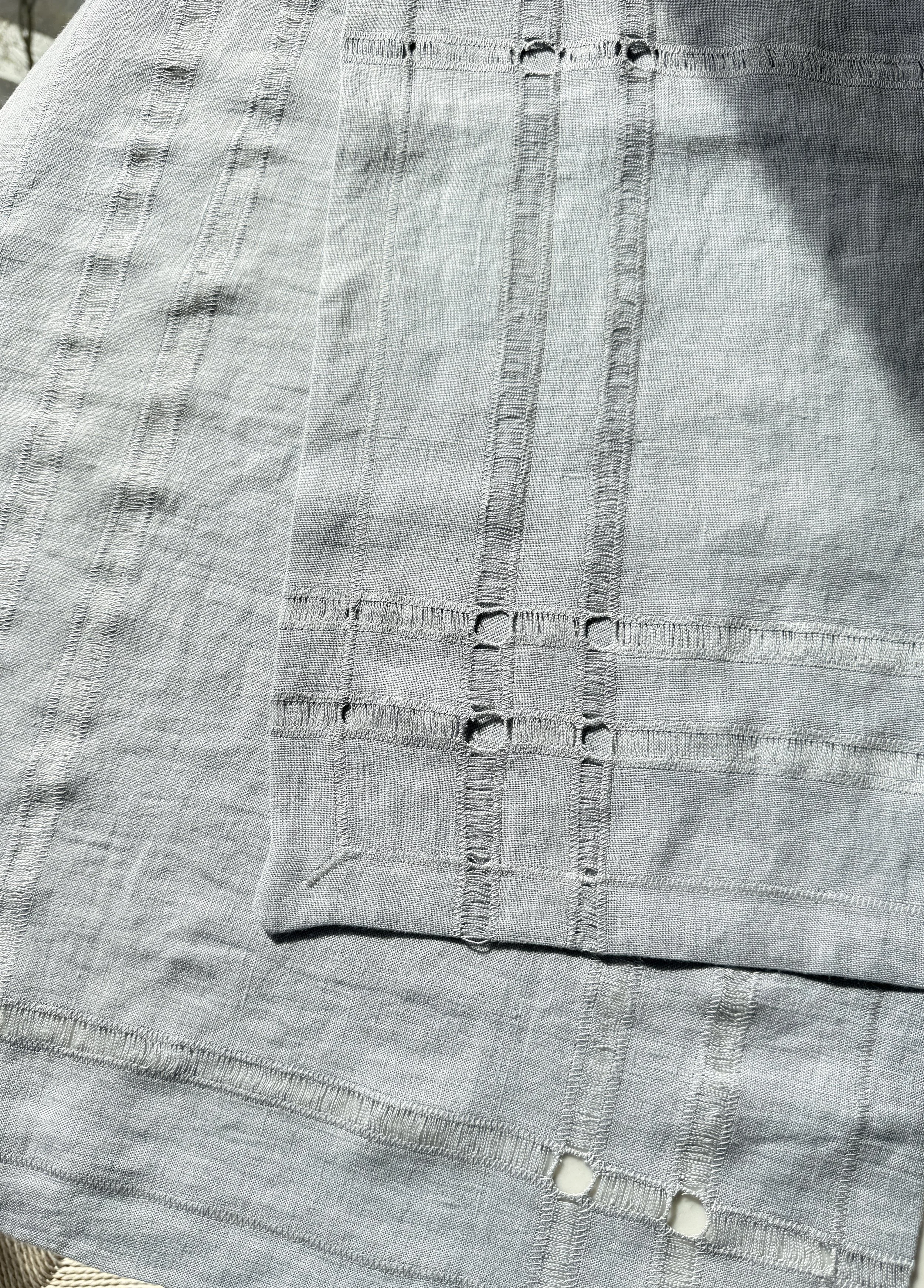 Close detail of hand-pulled hemstitch on Gray Pearl European linen napkin lit by sunschine