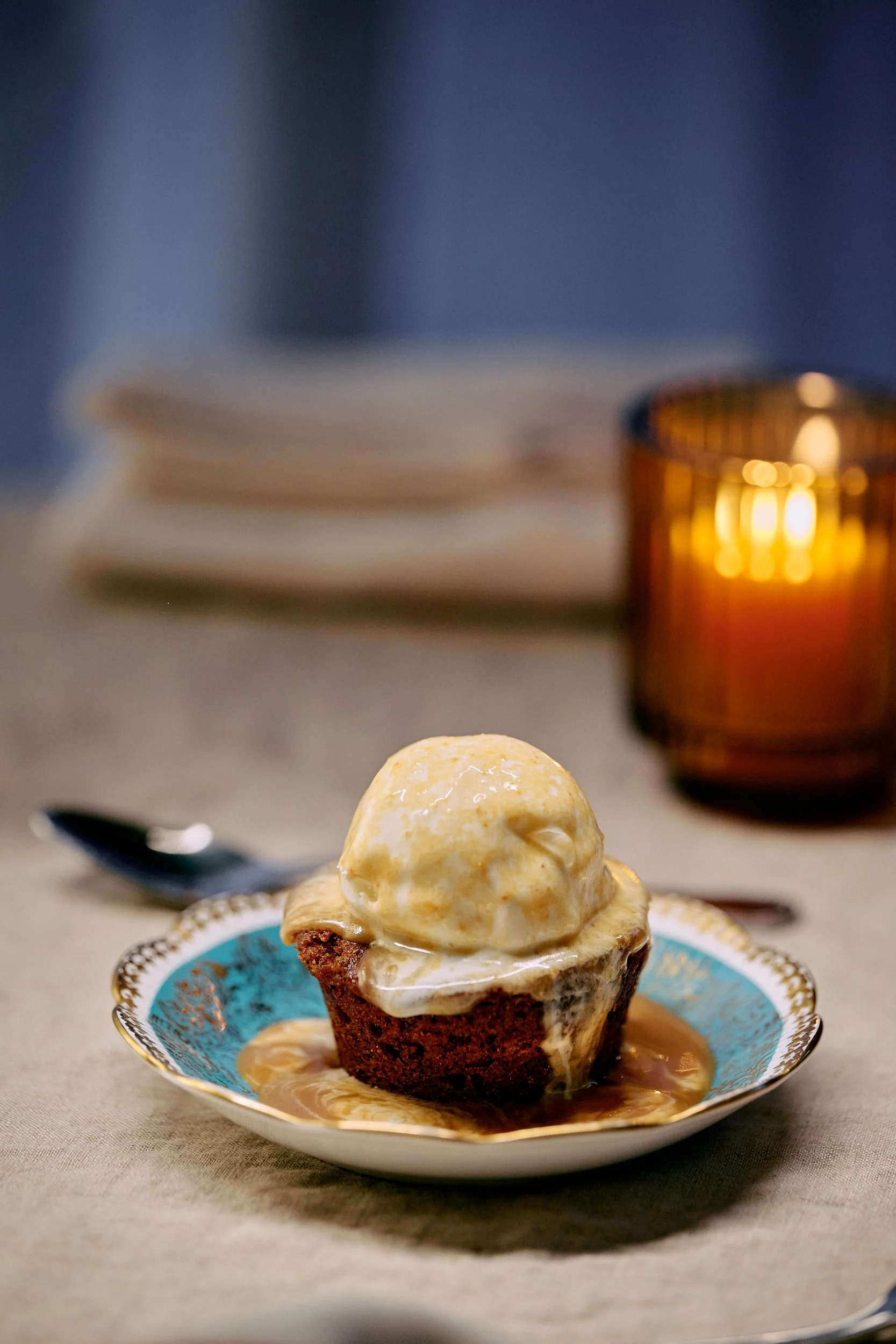 Cupcake au chocolat avec glace à la vanille et sauce caramel sur une assiette décorative.