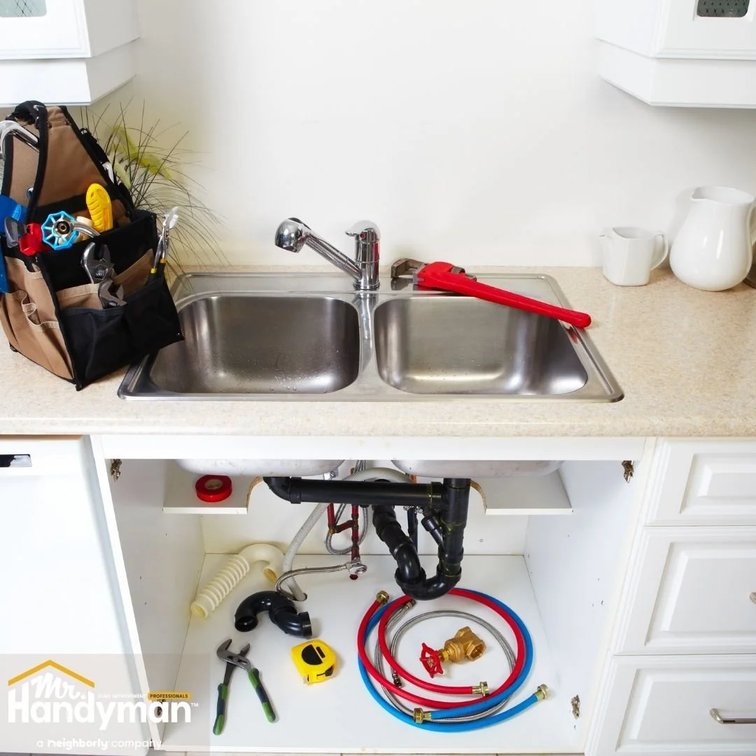 Under-sink plumbing repair with tools and replacement parts, home plumbing service by Mr. Handyman of Lehigh Valley