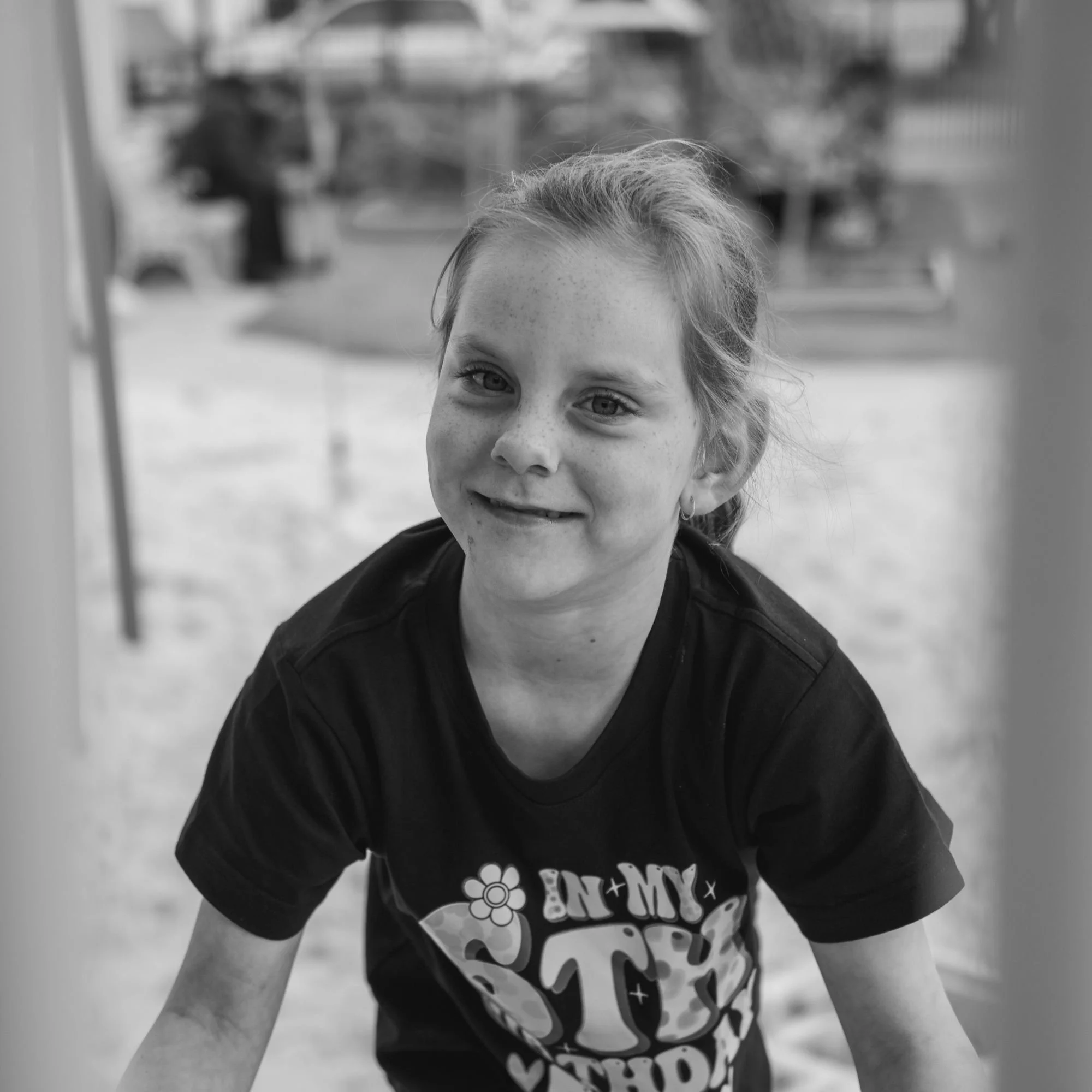 Portrait of a girl at a playground wearing a birthday tshirt