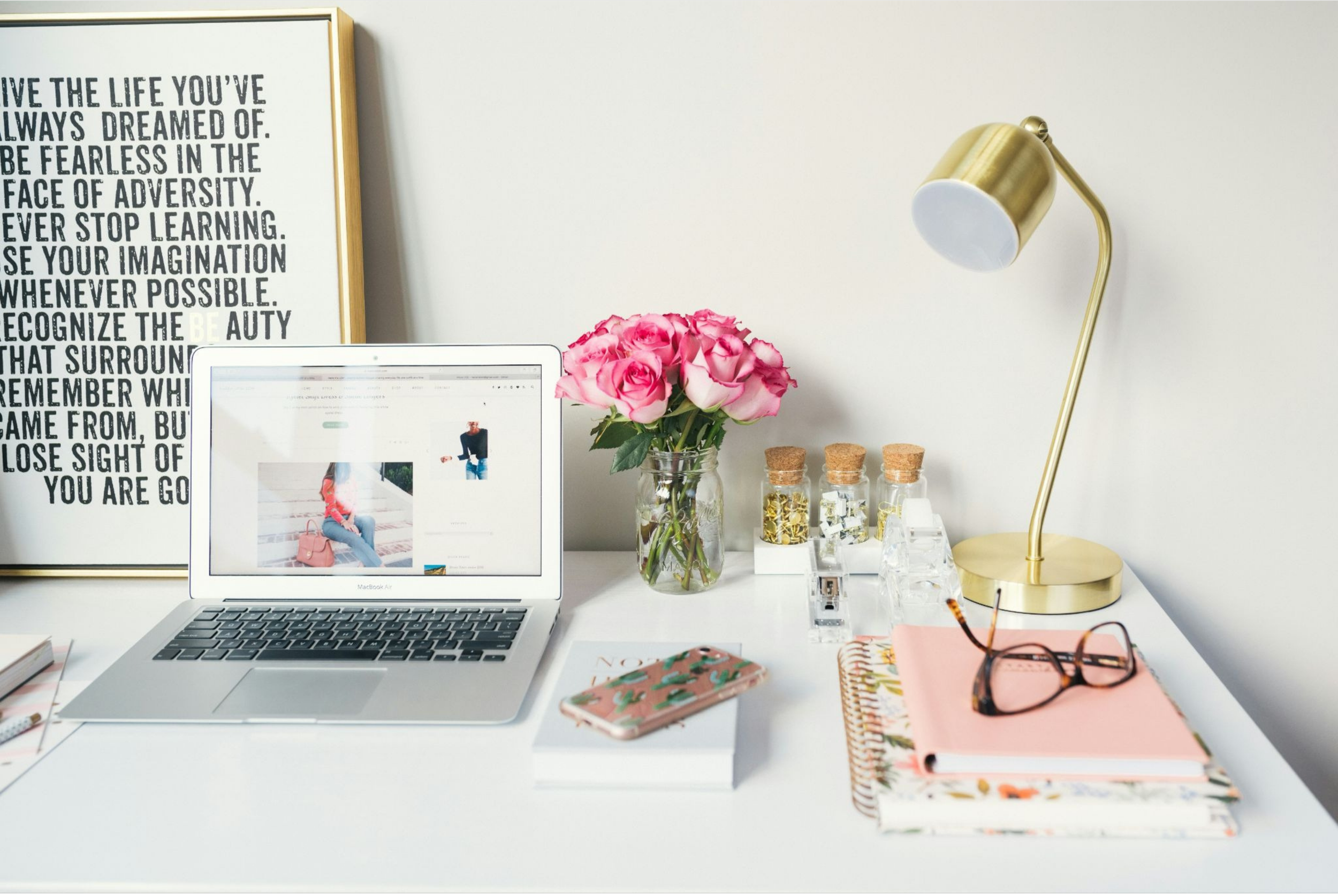 Small home office work zone featuring a white rolling storage cart and wicker baskets in a living room corner.