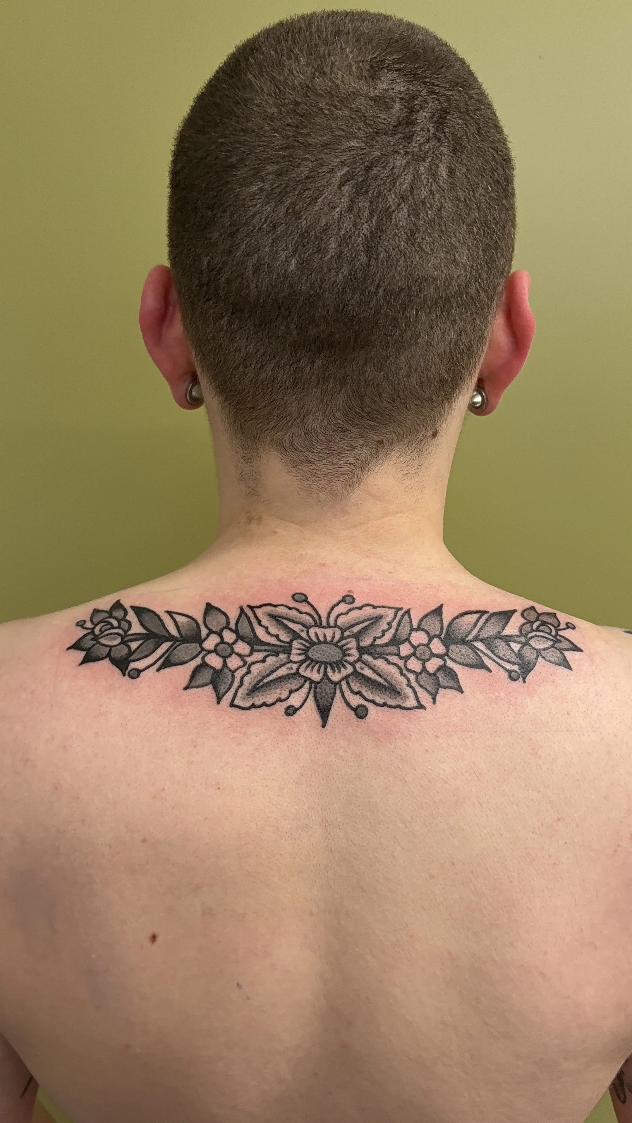 american traditional style black and grey floral back tattoo