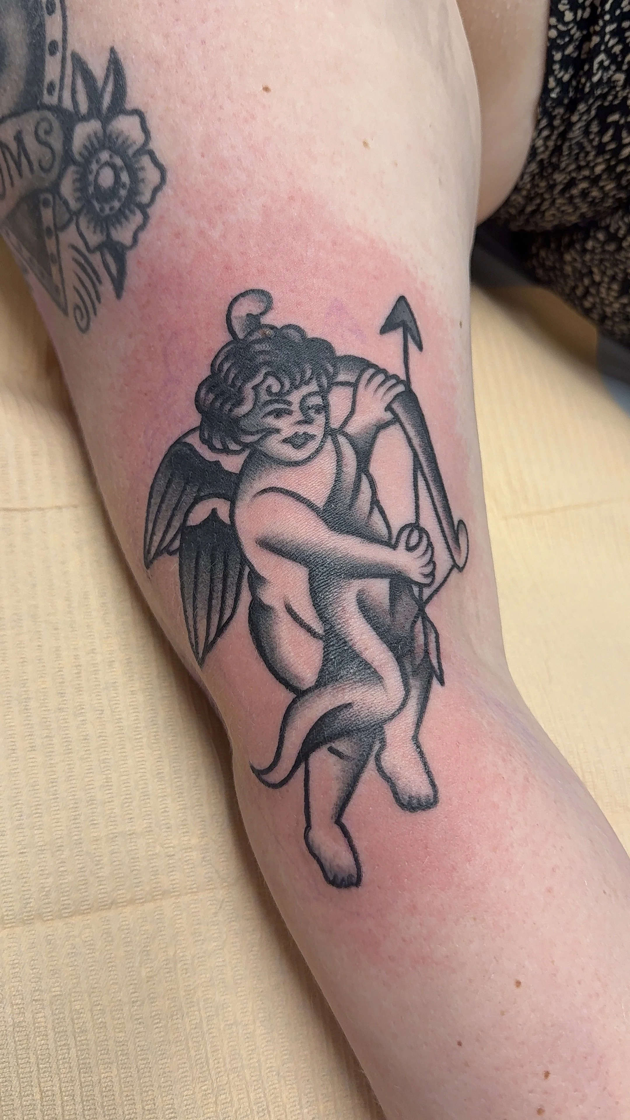 american traditional style cherub tattoo in black and grey