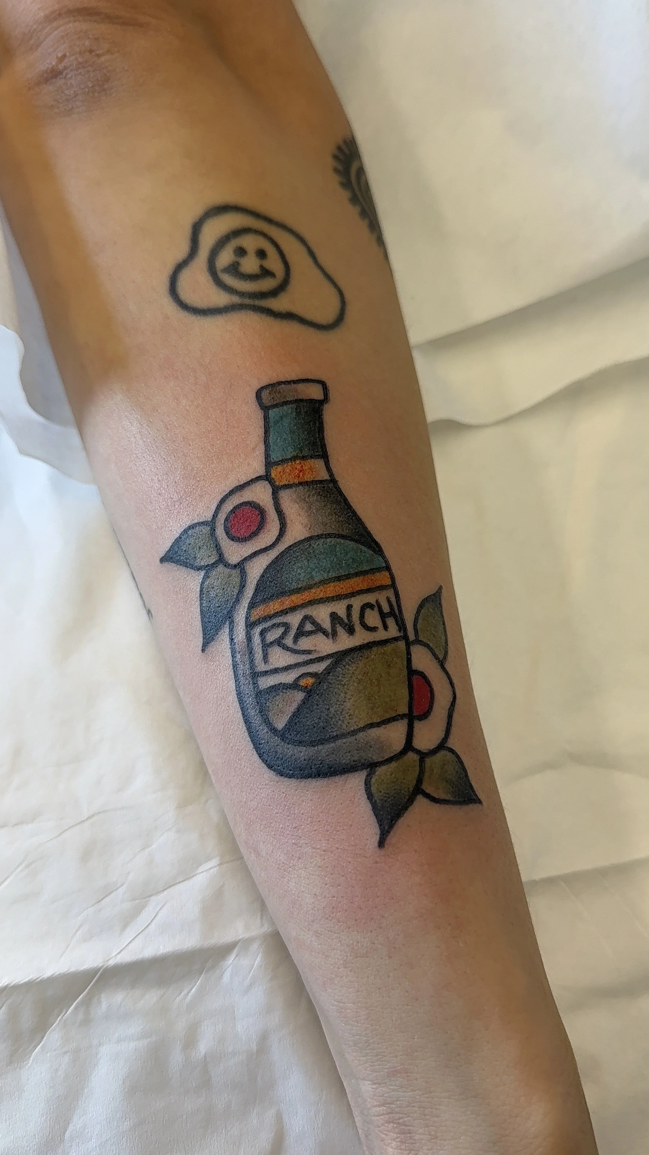 Tattoo of a bottle of ranch dressing.