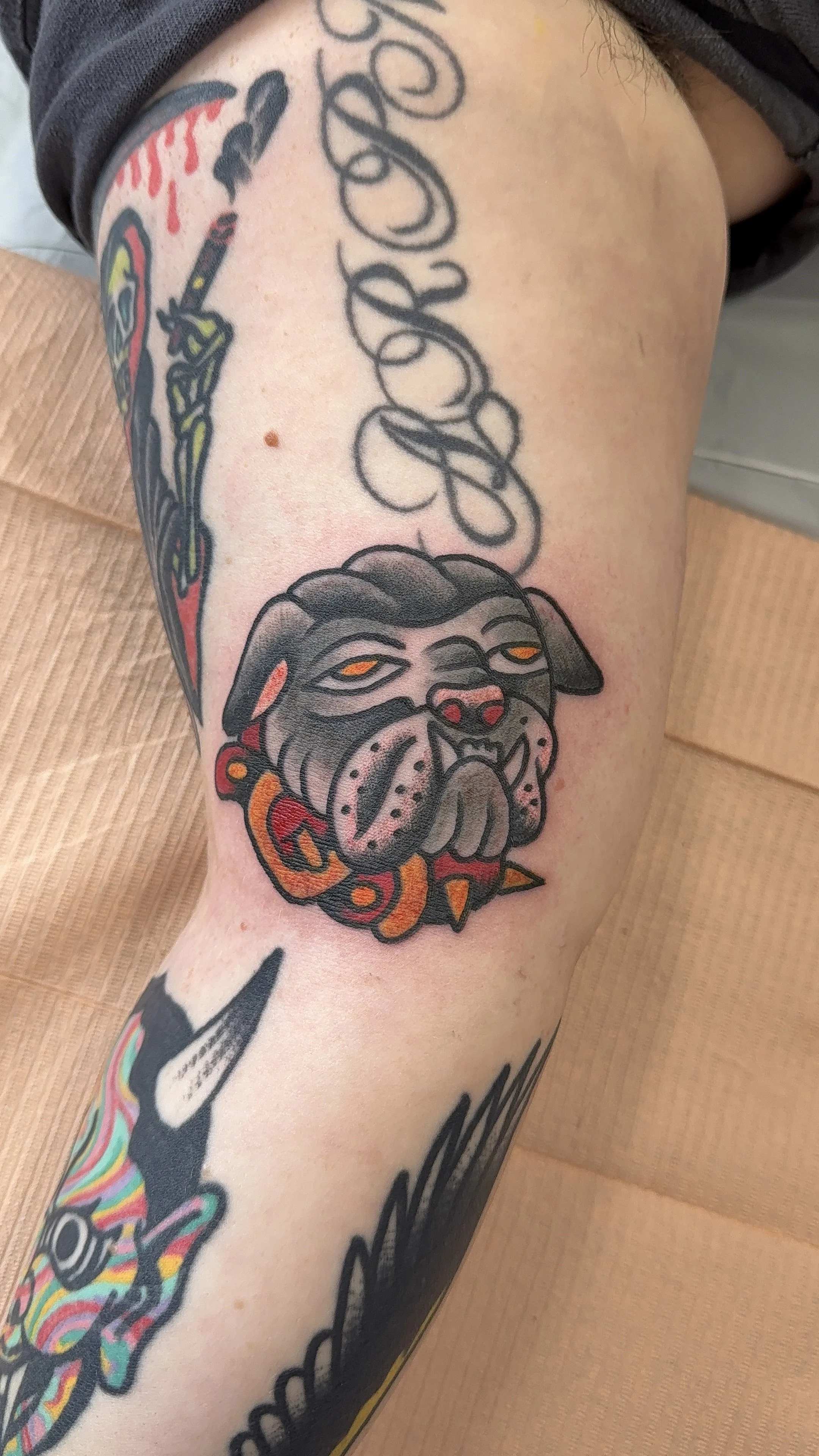 Tattoo of a bulldog's face on a person's upper arm or shoulder.