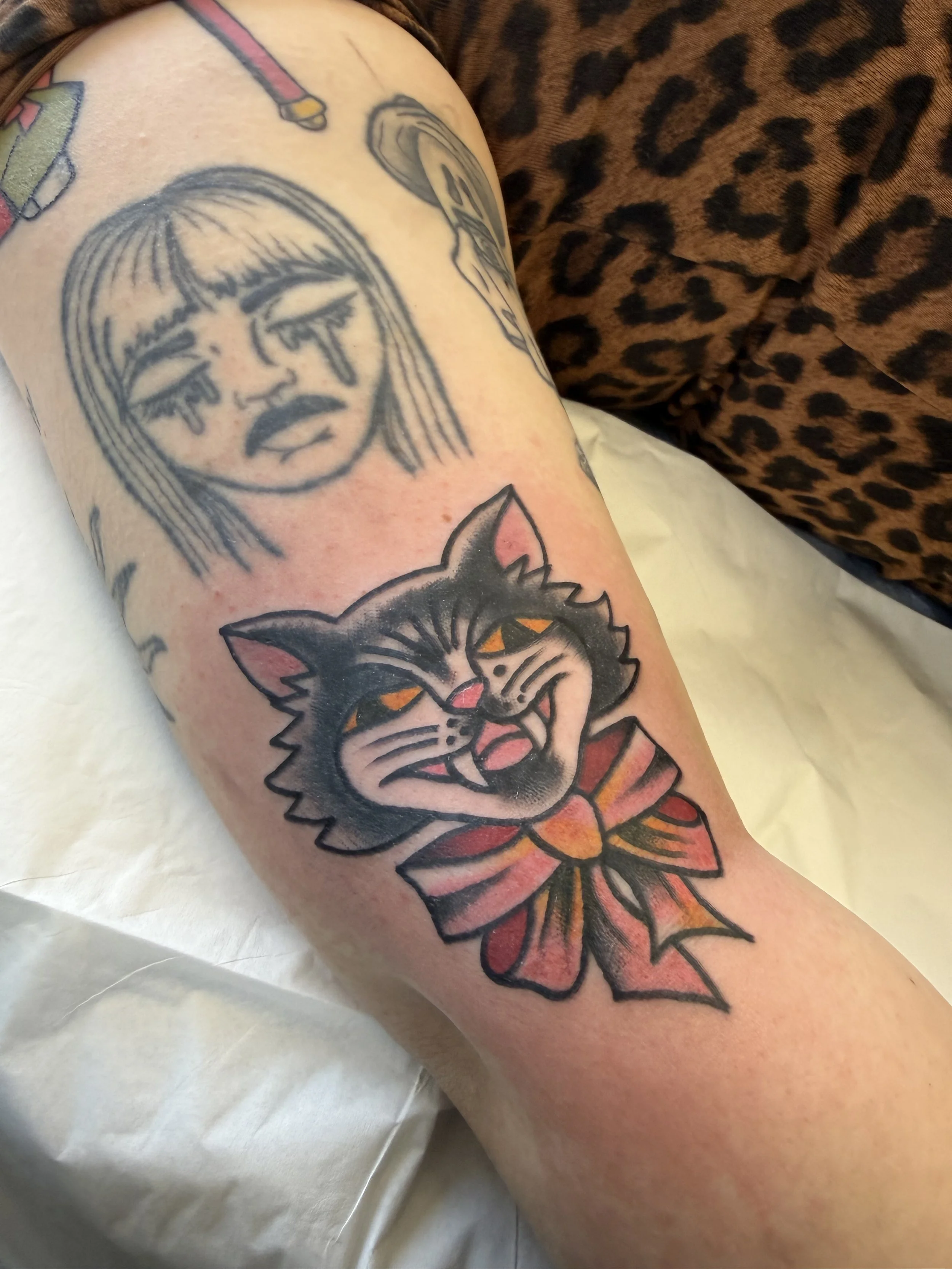 tattoo of a cat wearing a bow