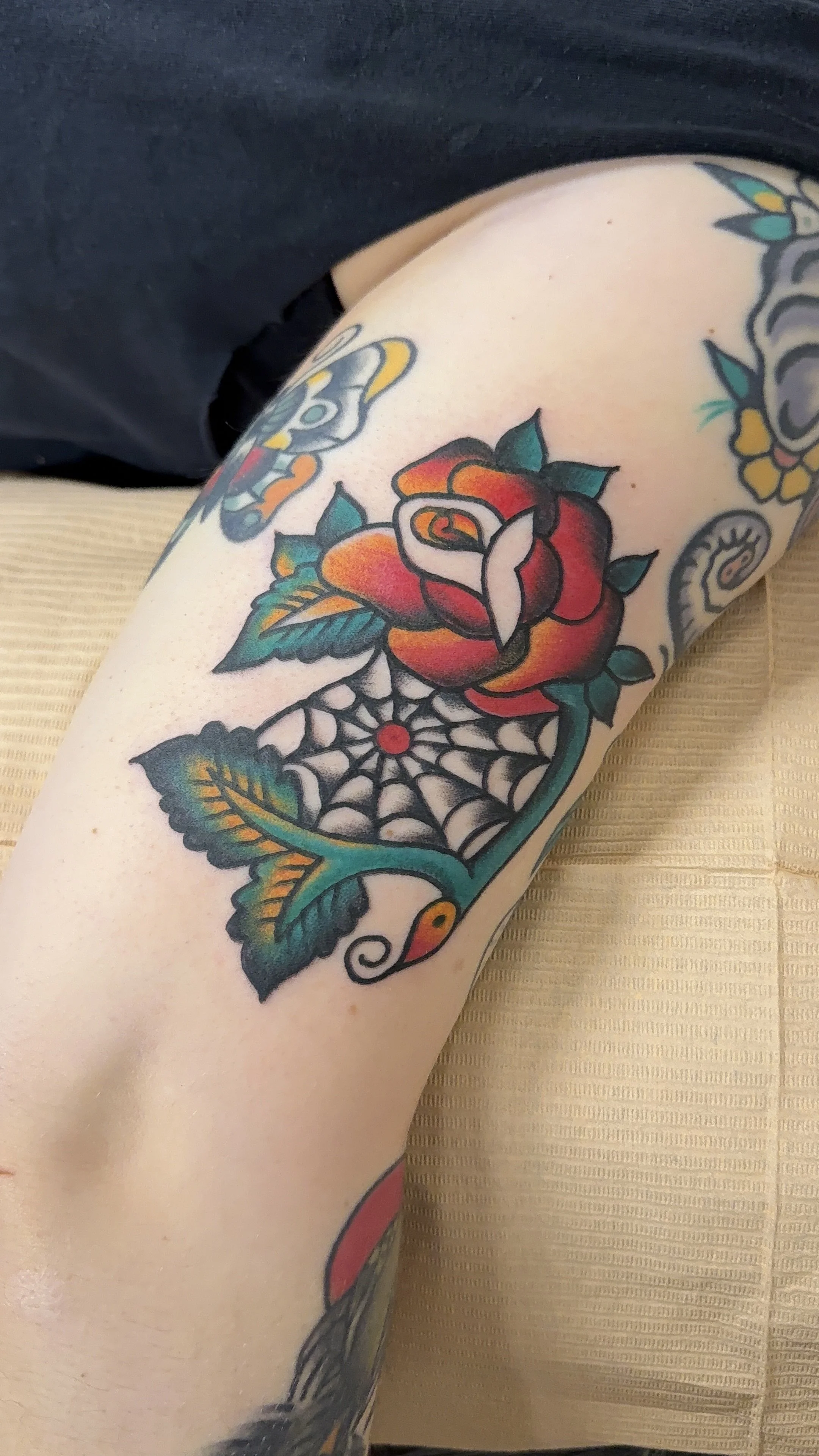 american traditional style colorful rose and spiderweb tattoo 
