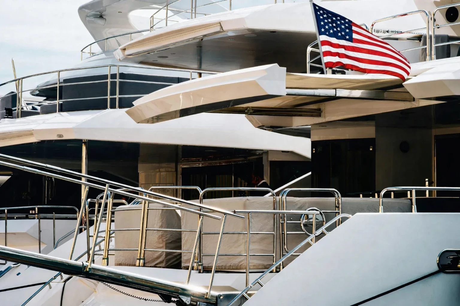Superyacht docked at marina with U.S. flag, showcasing corporate and private yacht advisory services