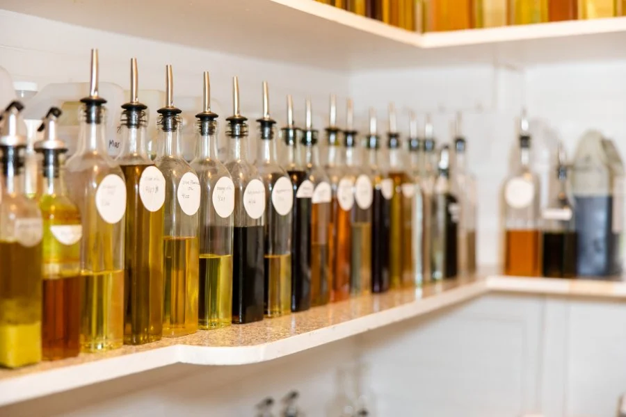 Three ceramic spoons each holding dried herbs, arranged vertically against a light background.