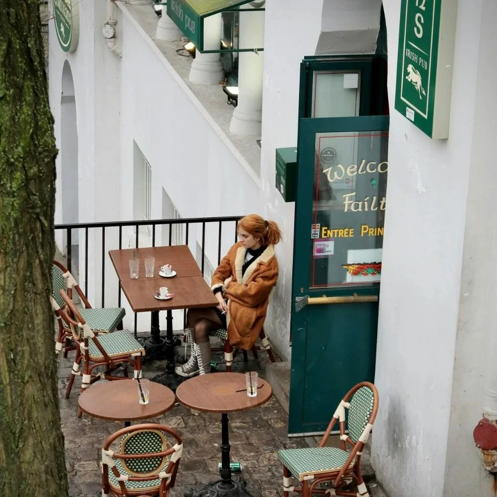 Kvinne sitter ved et kafébord i Oslo