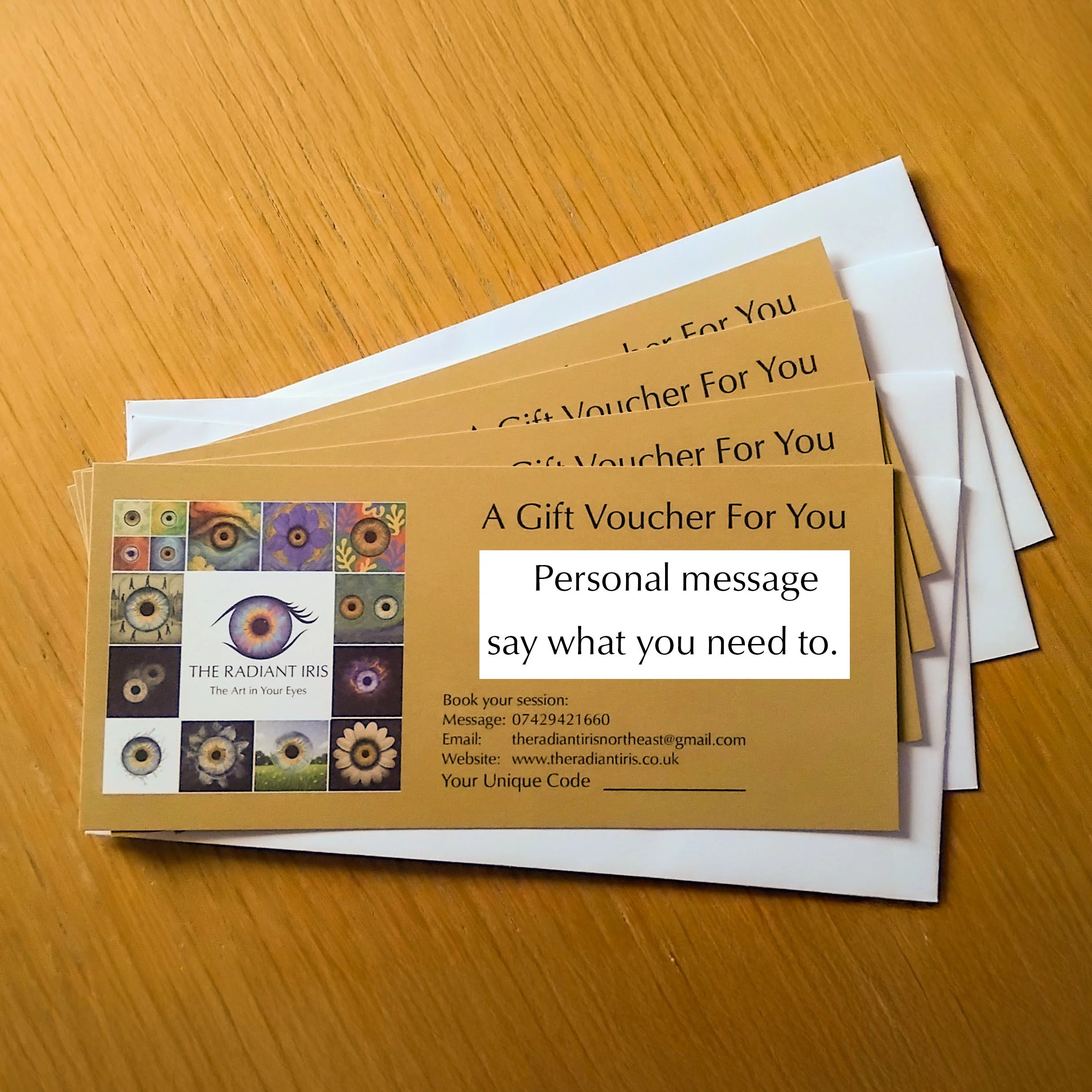 A stack of gift vouchers for 'The Radiant Iris' with a personal message card, placed on a wooden surface.