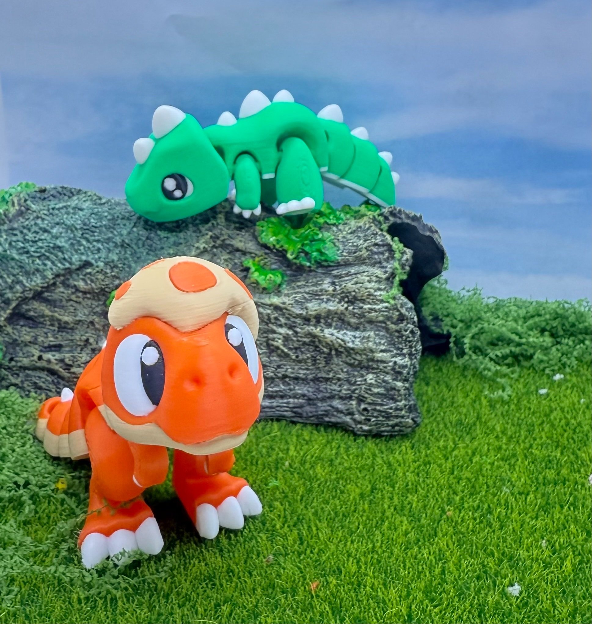 Orange T Rex with a piece of egg shell on his head, with a green stegosaurus x trex in the background resting on a (really really really big!) log.