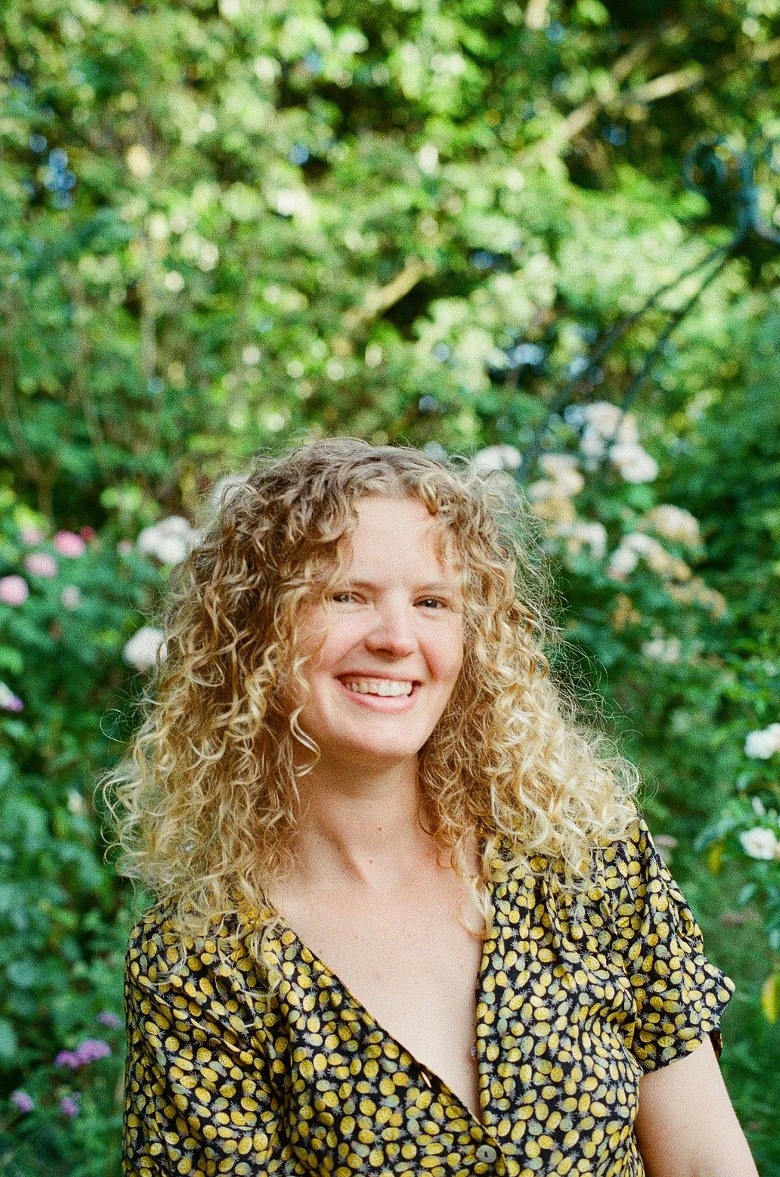 Femme qui montre ses muscles, avec une ceinture de chantier autour de la taille, on voit qu’il y a un chantier en fond , derrière elle. Elle porte un bandana bleu sur les cheveux et des lunettes de soleil.