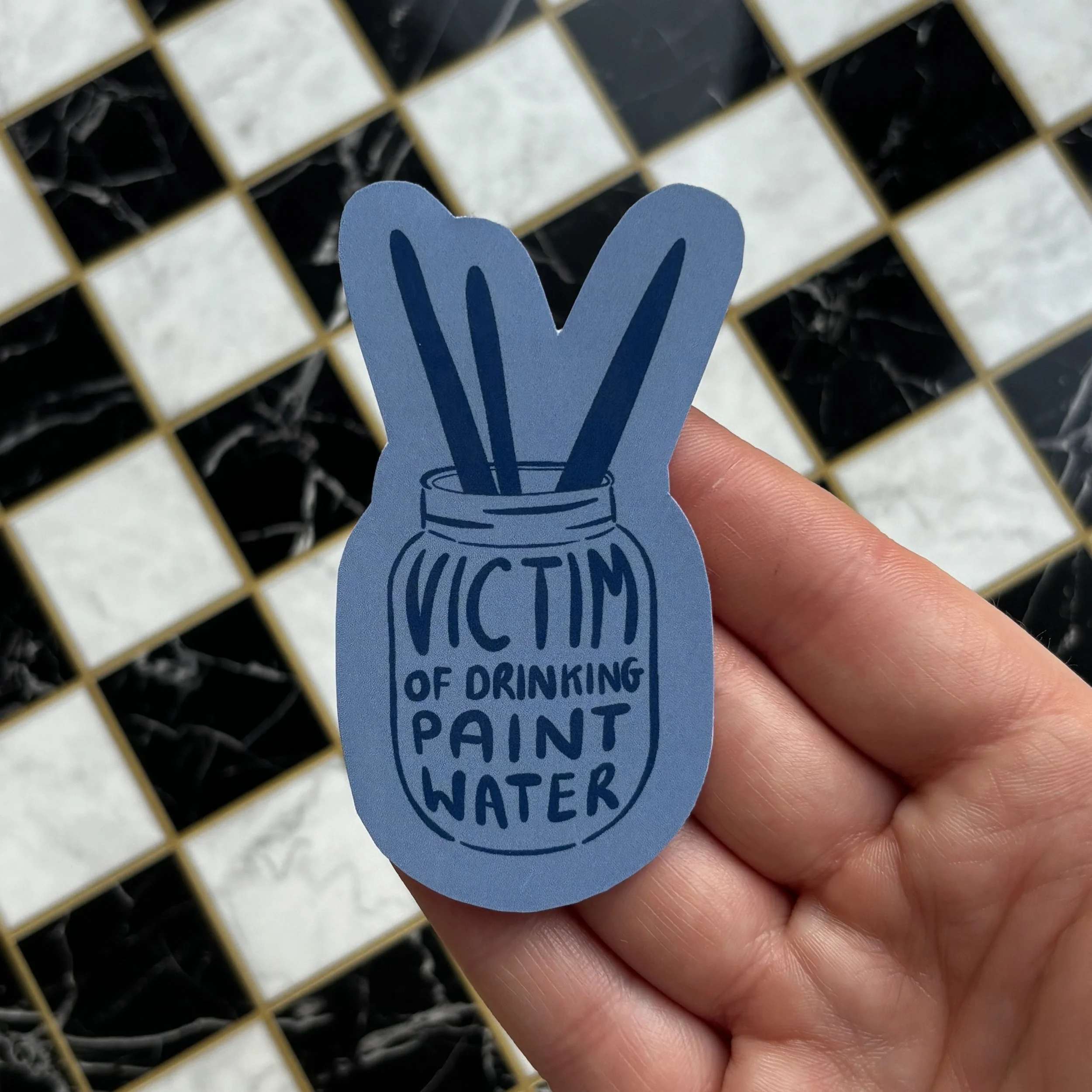 victim of drinking paint water holding over checkerboard.jpg