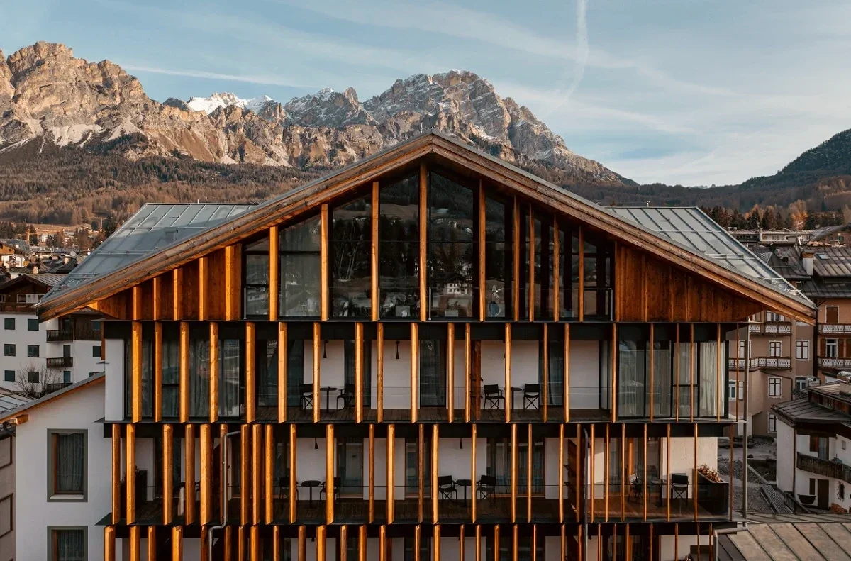 Hotel de Len in Cortina d’Ampezzo with timber architecture and Dolomite mountain backdrop. 