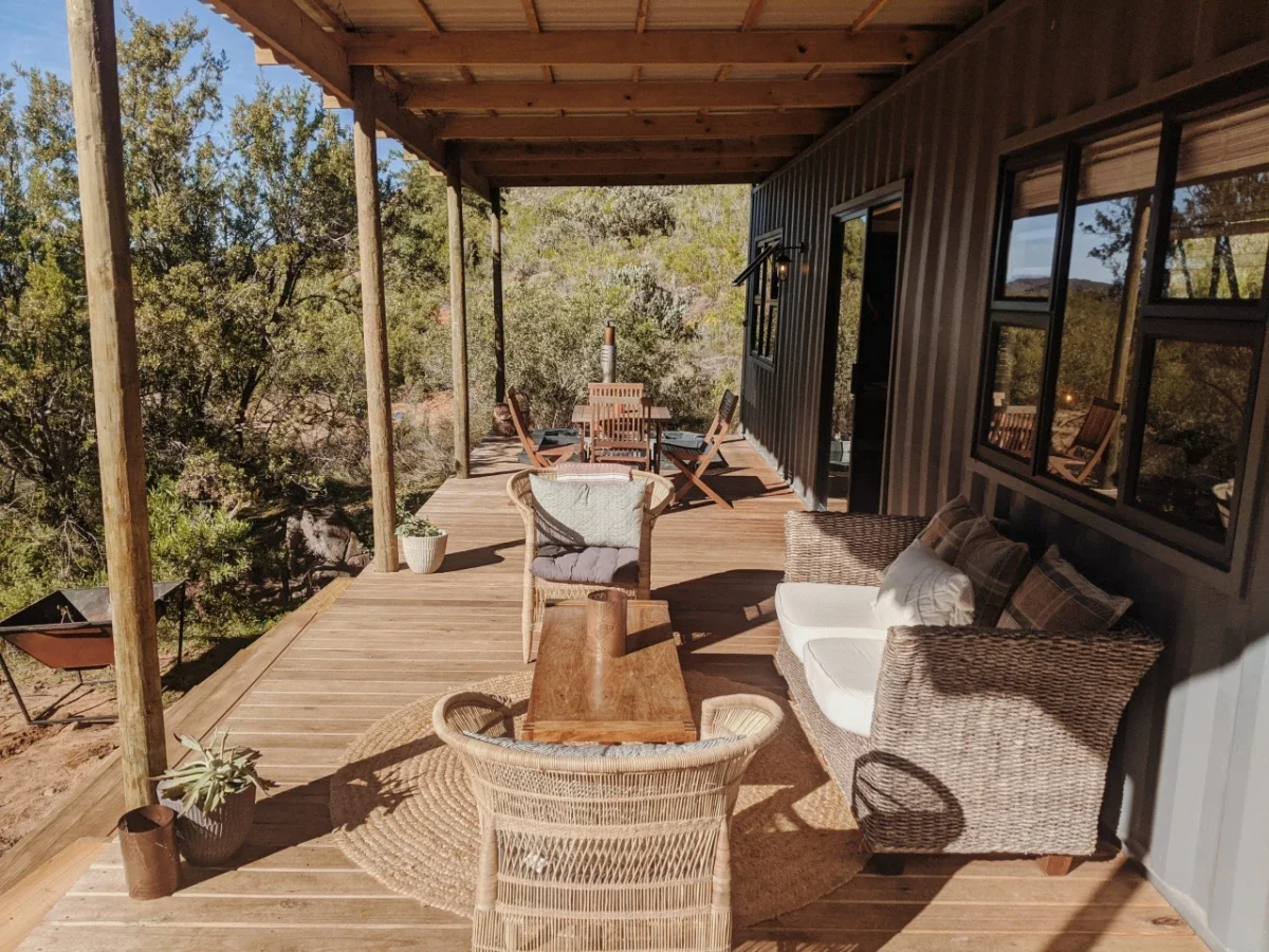 Leopard Valley eco cabin surrounded by seasonal wildflowers and mountain terrain in a remote valley setting.