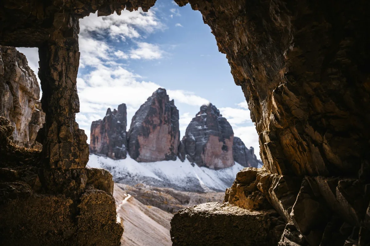  Tre Cime di Lavaredo viewed through a rocky cave opening in the Dolomites. 