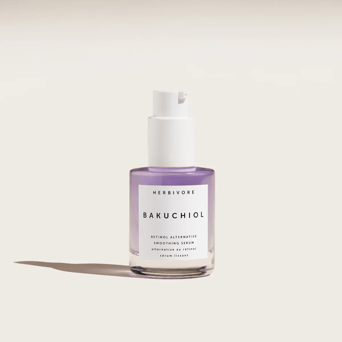 Clear glass bottle filled with lavender-hued Herbivore Bakuchiol Smoothing Serum.