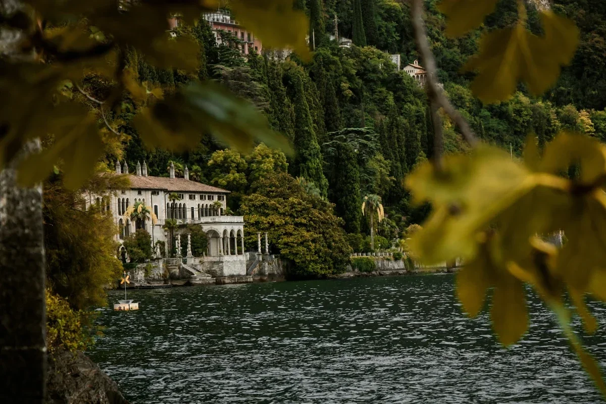 Historic lakeside villa framed by cypress and lush forest on the tranquil shores of Lake Como. 