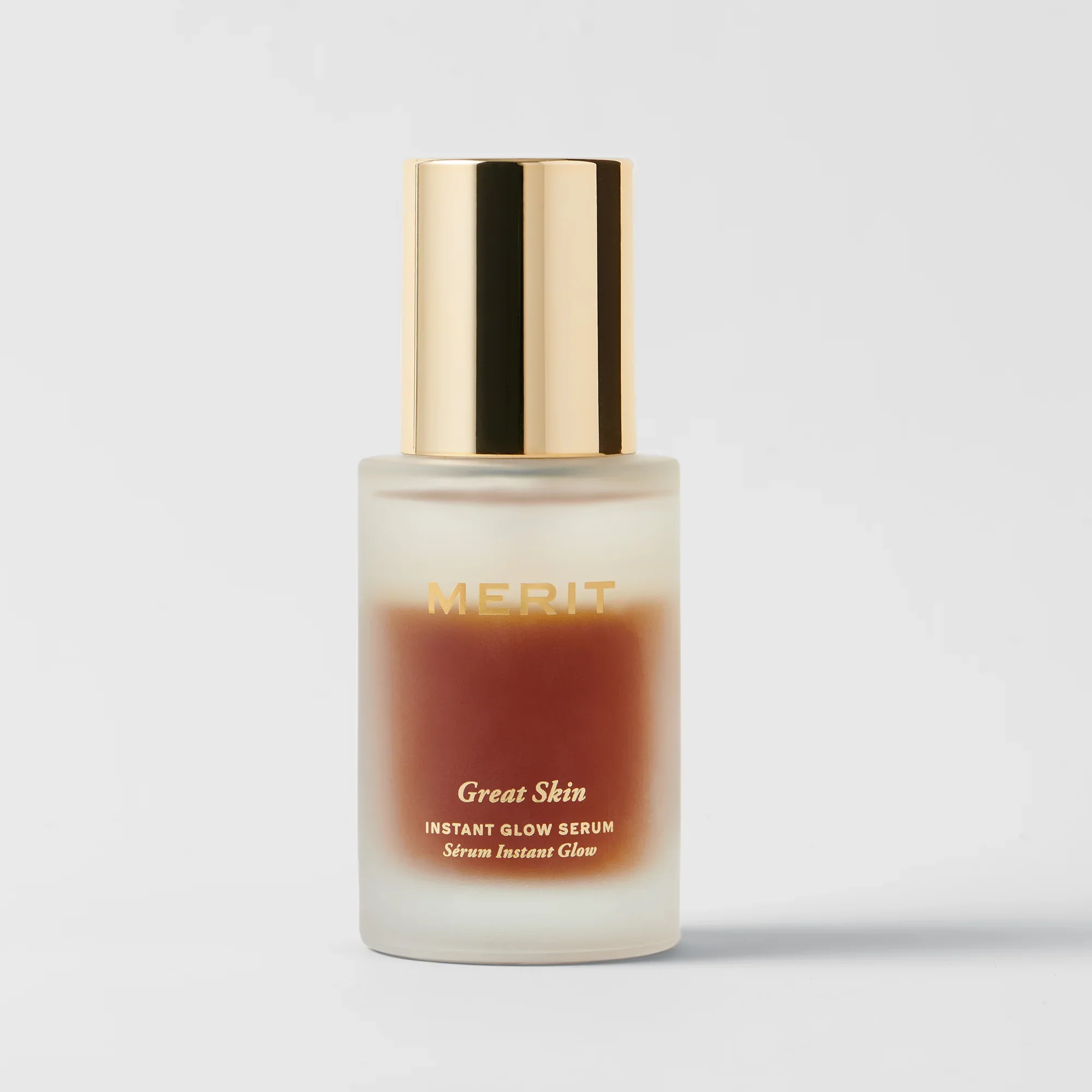 Merit Beauty Great Skin Instant Glow Serum in frosted glass; bi-phase amber formula topped with a gold metallic cap. 