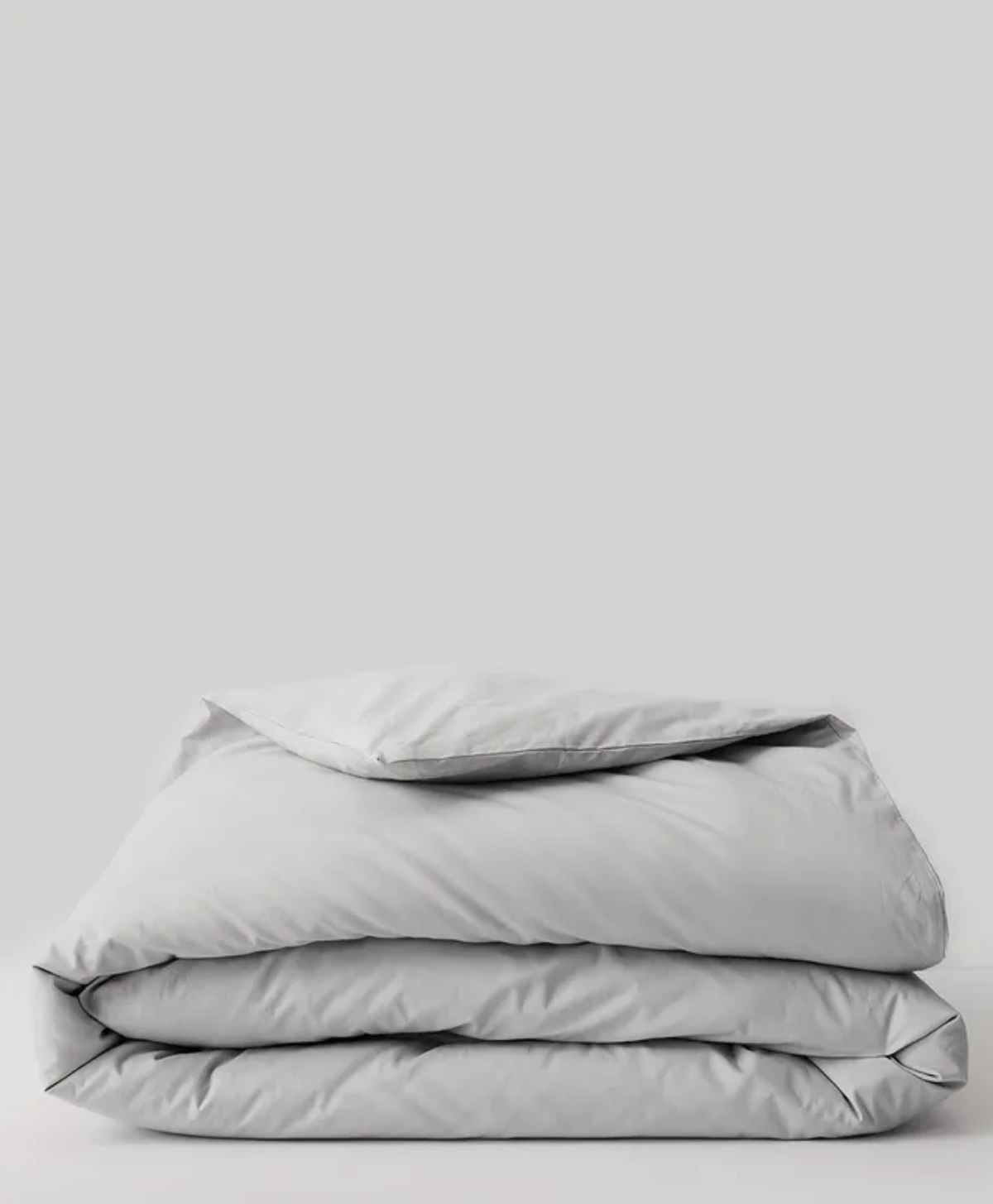 Folded Pact Organic Cool-Air Percale duvet cover in soft grey on minimalist background.