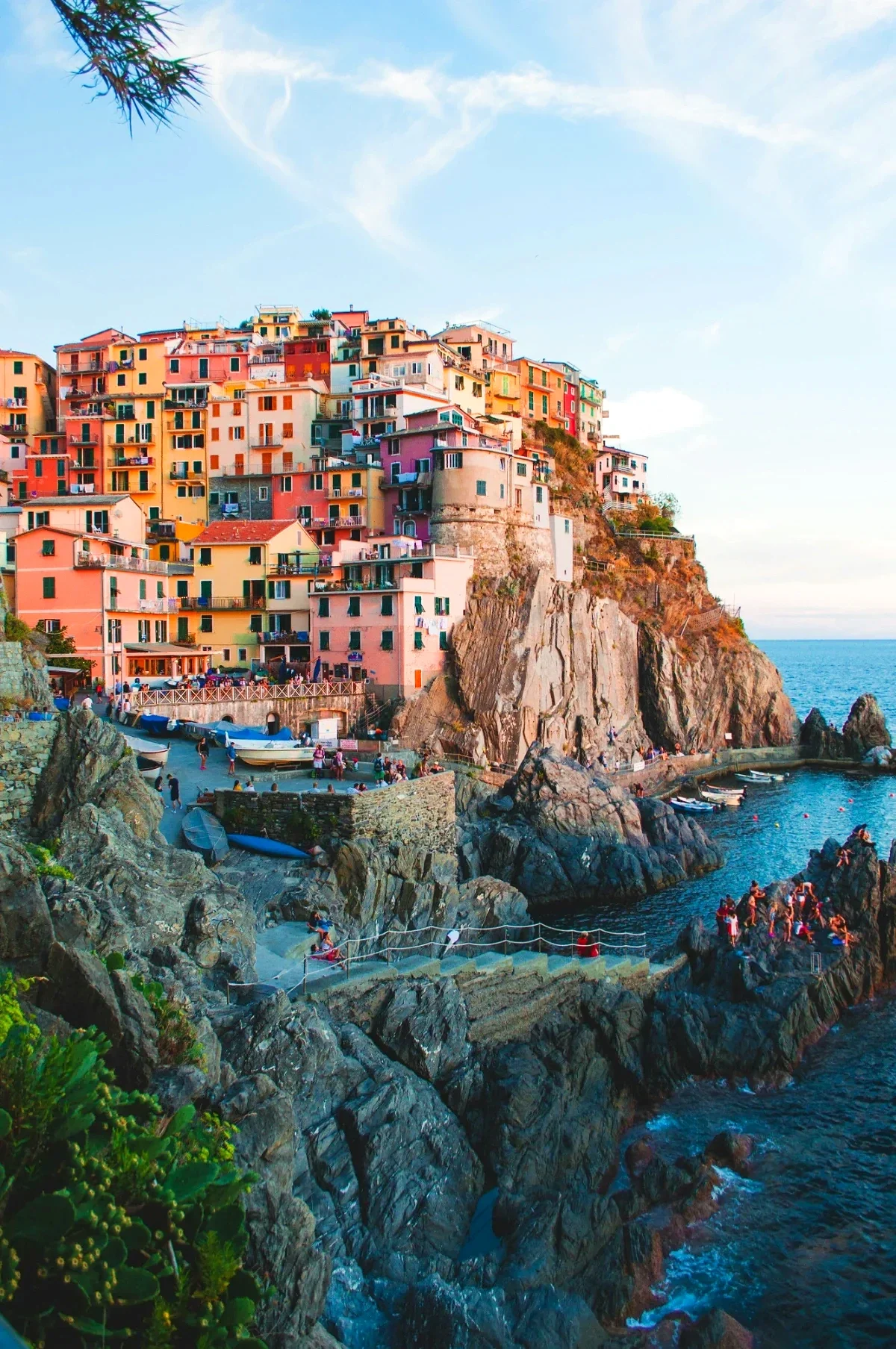 Golden-hour light on Manarola’s stacked cliffside houses overlooking the rocky Ligurian coastline. 