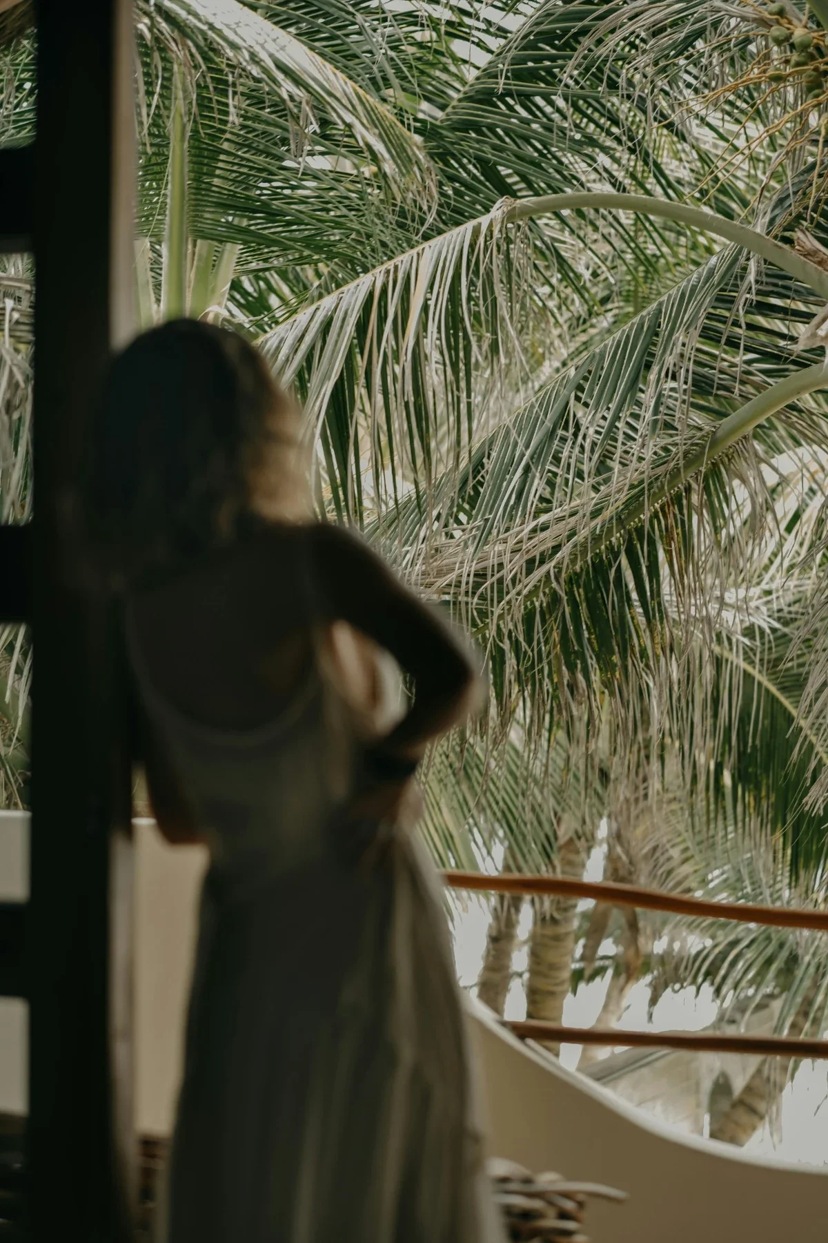  Blurred silhouette of a woman on a shaded balcony in gentle daylight. 