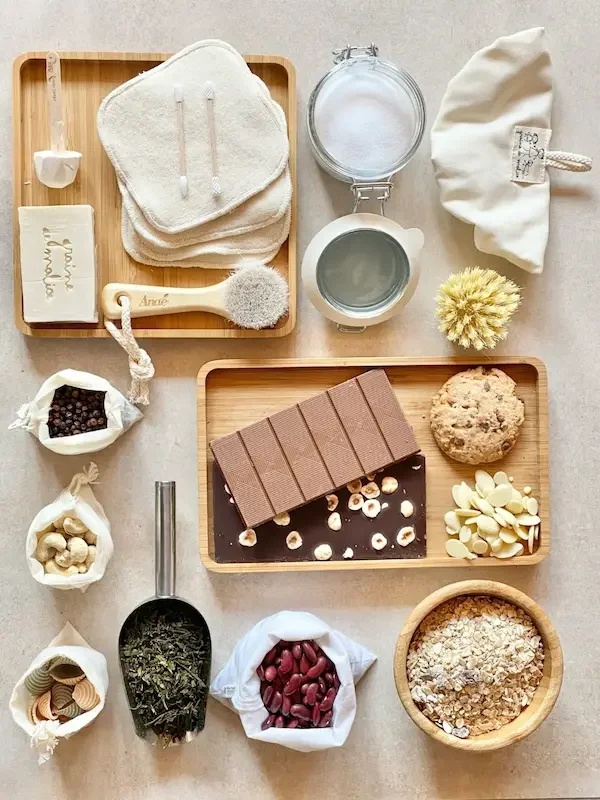 Overhead display of cotton pads, wooden brushes, jarred oats, nuts, chocolate bar and other package-free pantry staples.
