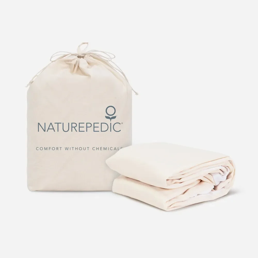  Naturepedic organic waterproof mattress pad neatly folded beside its cotton drawstring storage bag. 