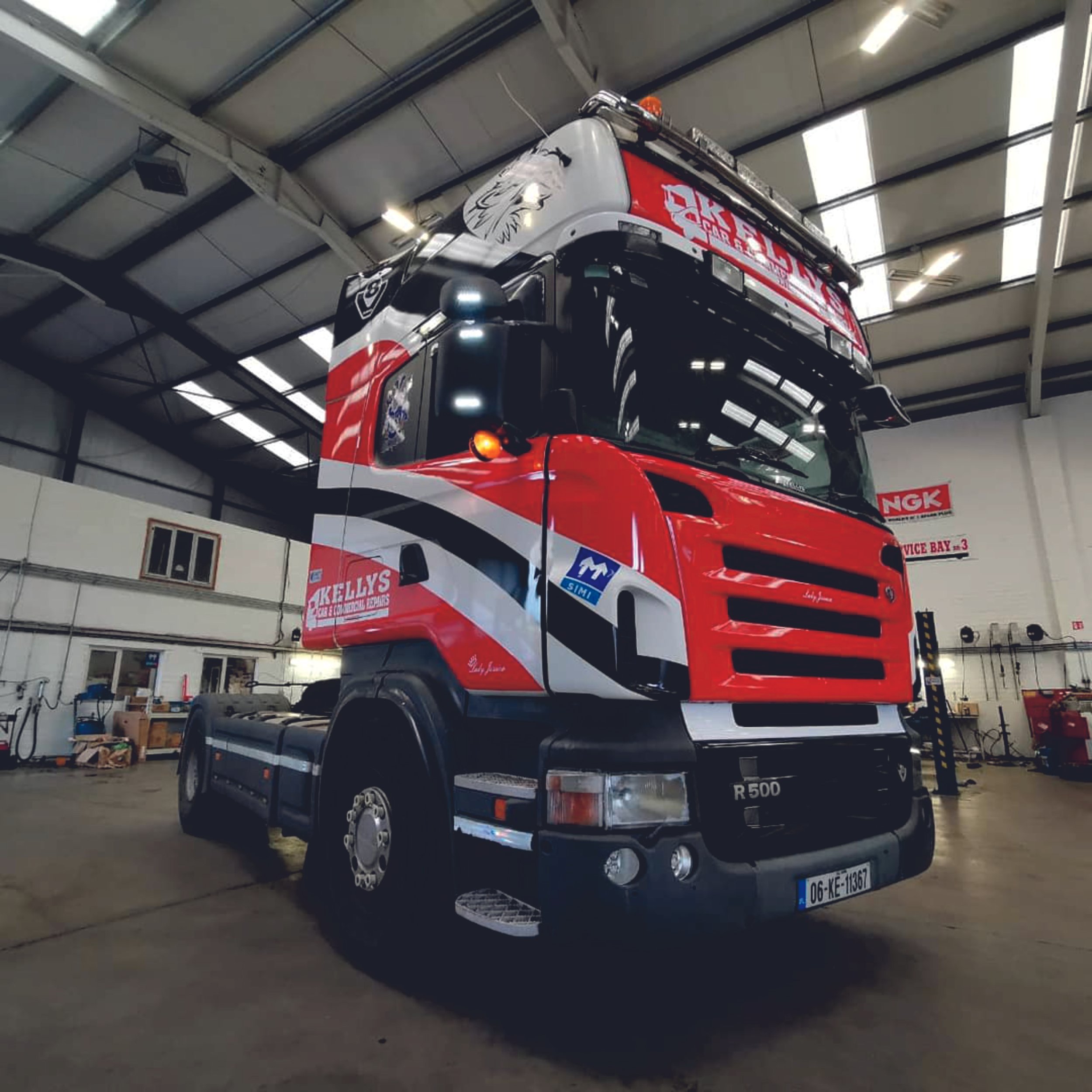 Red Scania R500 truck inside a workshop with branding on the sides and reflective surfaces. Vehicle wrap. Vehicle Graphics. Commercial Vehicle Branding. Signmakers Cork & Kerry, Ireland.
