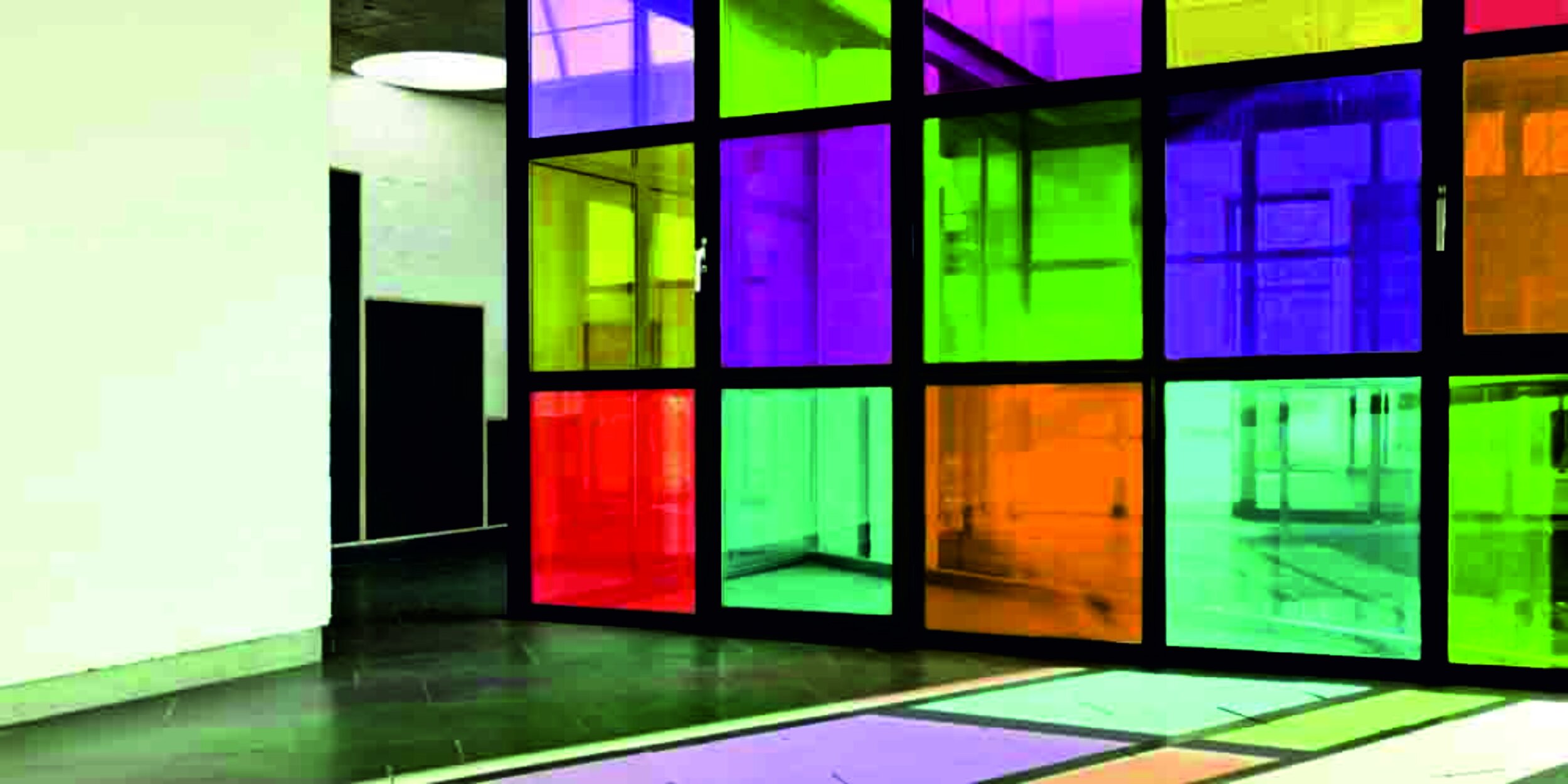 Interior with a modern glass wall featuring colorful squares in purple, green, yellow, orange, and red, creating a vibrant look. Signmakers Cork & Kerry, Ireland.