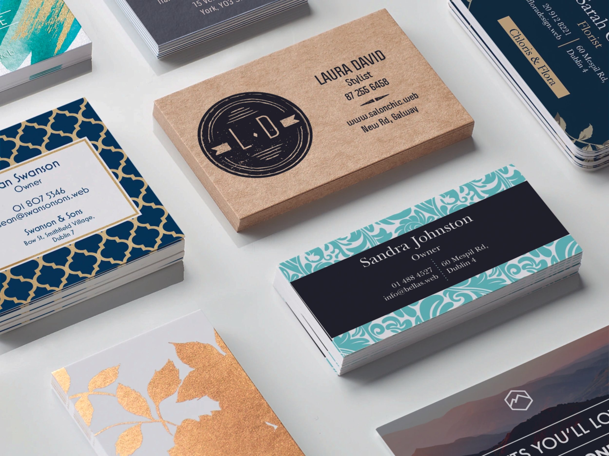 A collection of assorted business cards with various designs and text, featuring names, professions, and contact details. Some cards have decorative patterns and unique color schemes. Signmakers Cork & Kerry, Ireland.