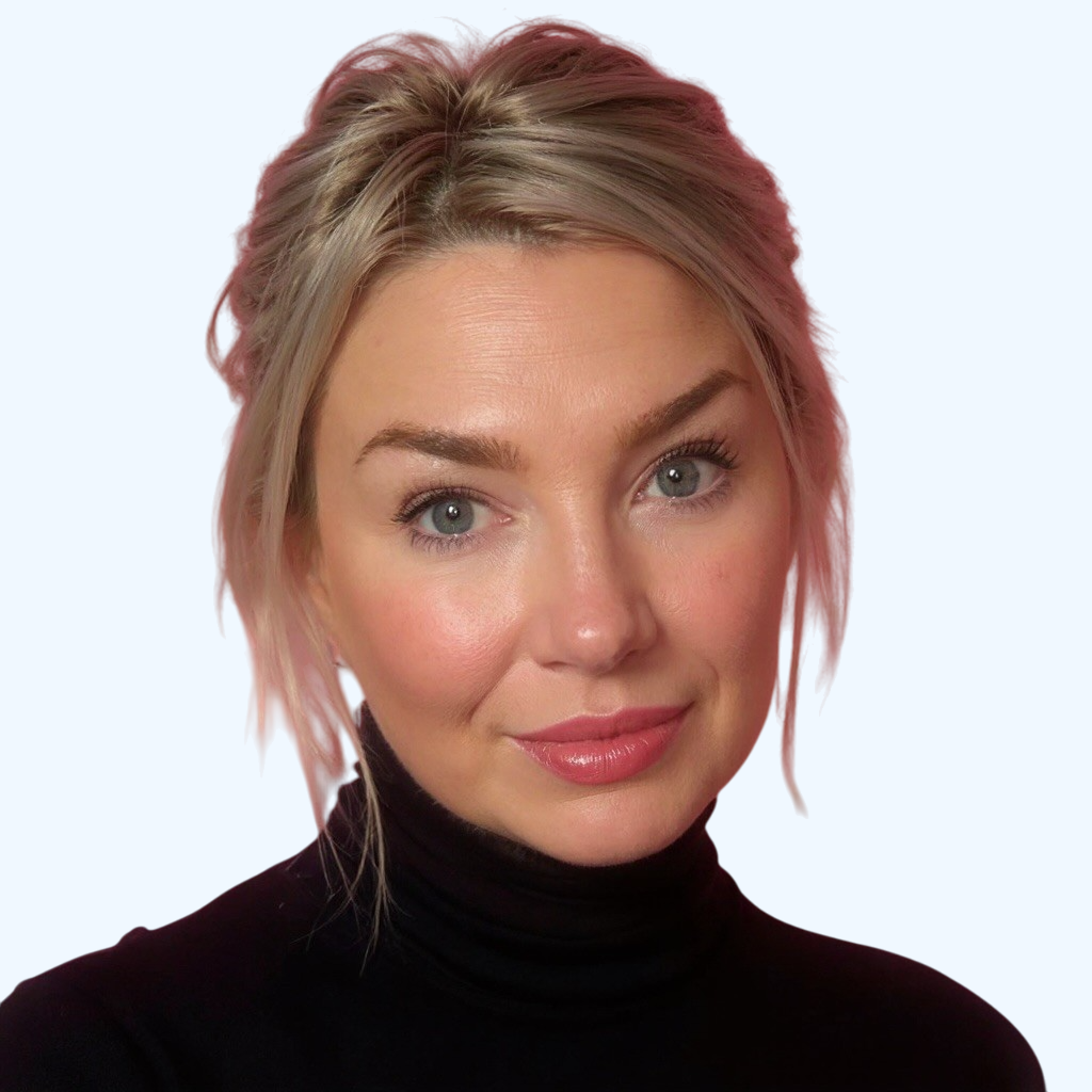 A woman with blonde hair styled in loose waves, wearing a black turtleneck, looking at the camera with a slight smile