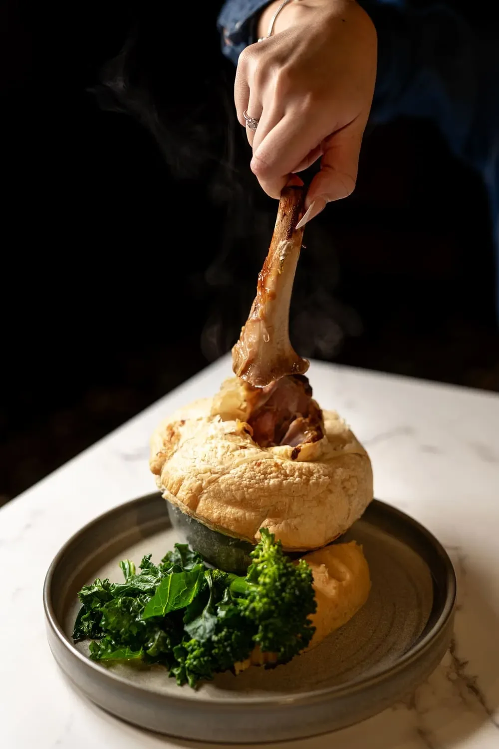 A guest enjoys the lamb shank pot pie