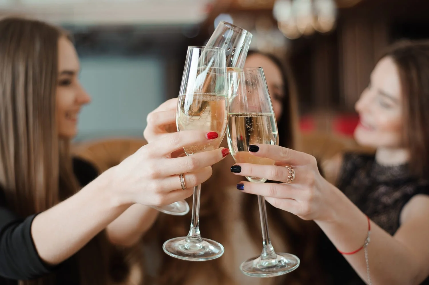 Three young woman toast with glasses of Prosecco