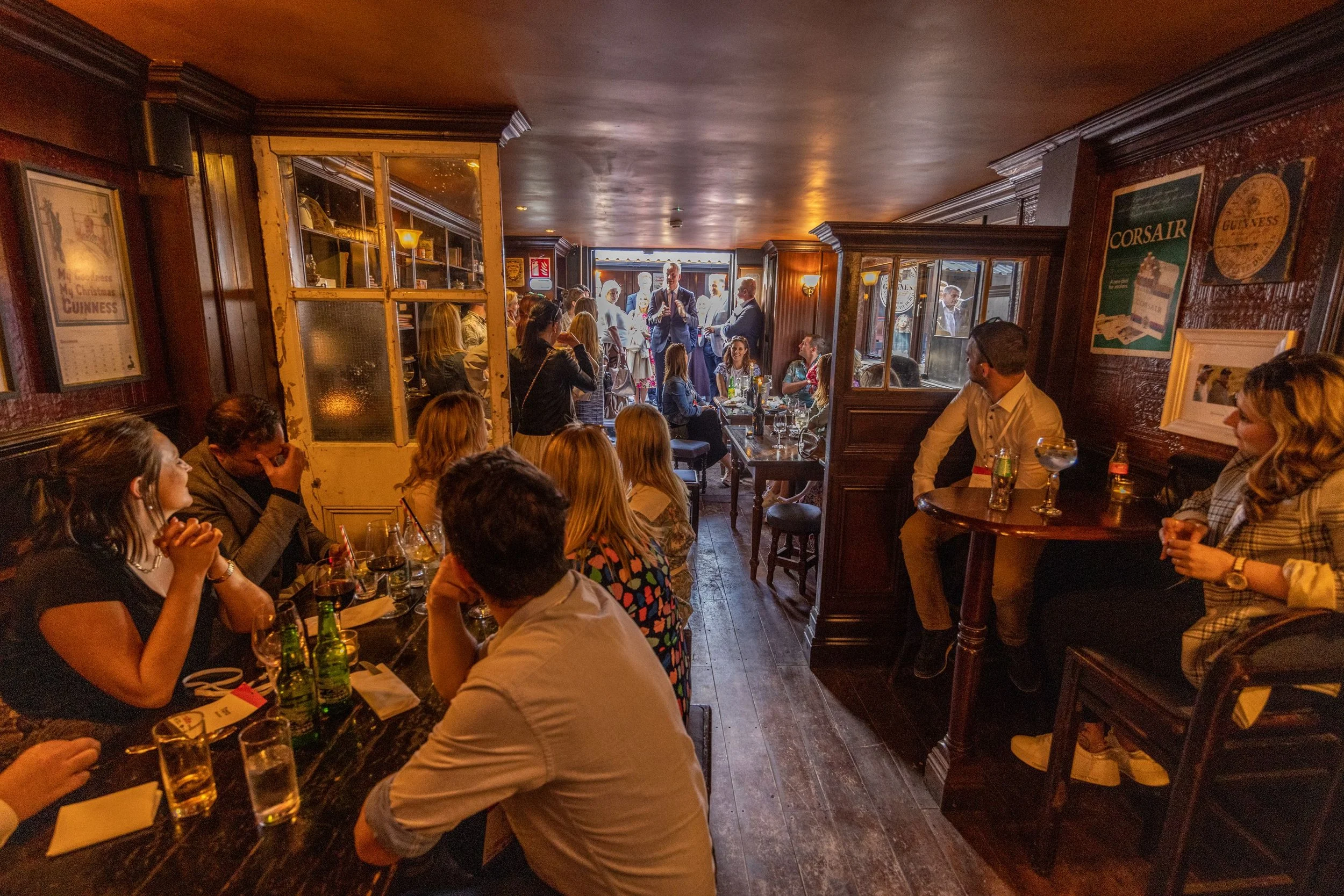 People sitting in a cozy pub, watching a performer