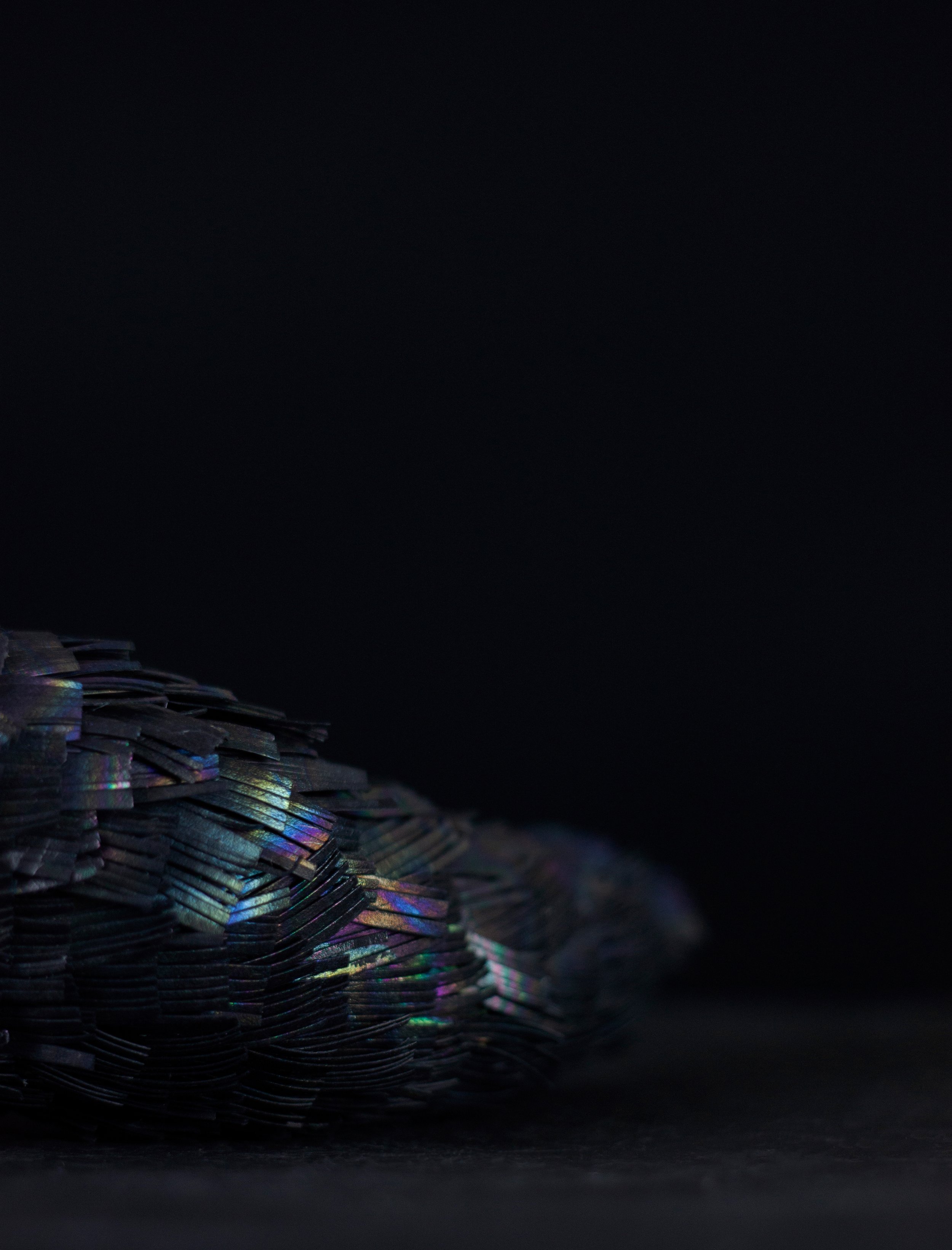 Close-up of a pile of shredded holographic material against a black background.