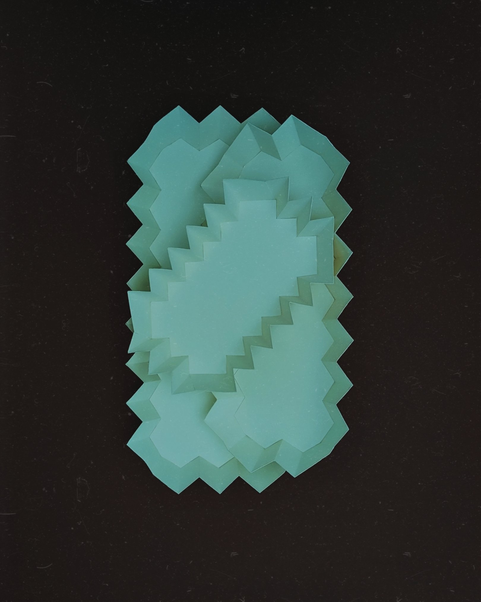 A stack of teal-colored star-shaped sticky notes on a black background.