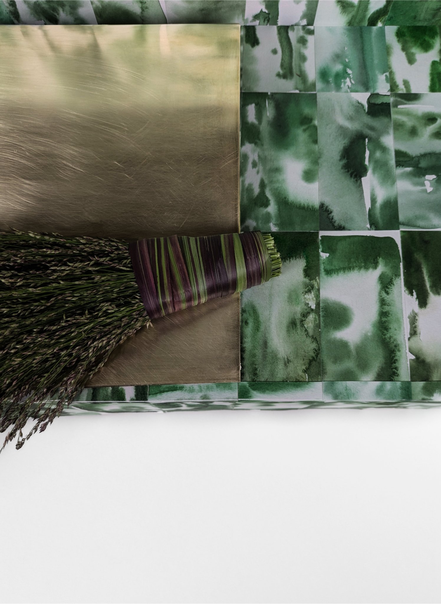 A bundle of dried lavender tied with purple and green striped string, placed on a brown surface against a green abstract patterned background.