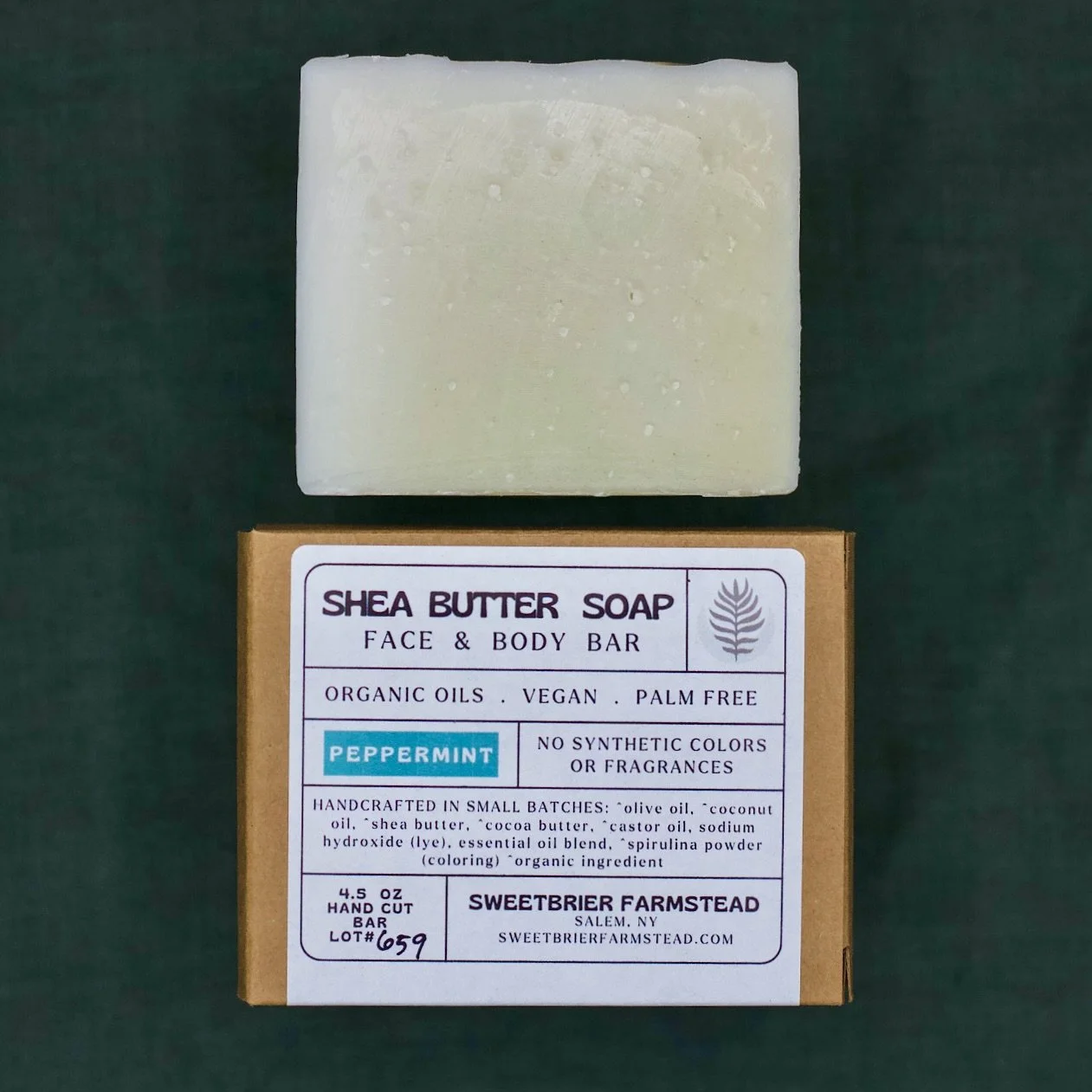 2 bars of Sweetbrier Farmstead natural Peppermint Bar Soap one in packaging on green background