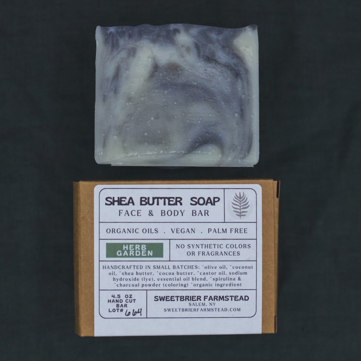 2 bars of Sweetbrier Farmstead natural Herb Garden Bar Soap one in packaging on green background