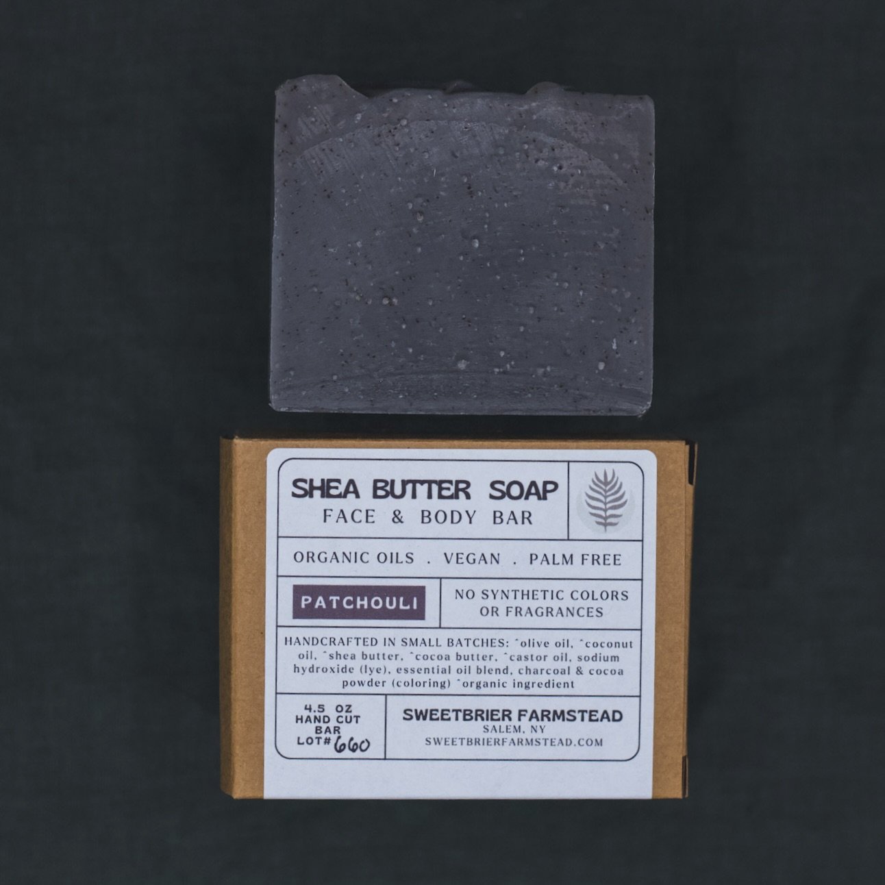 2 bars of Sweetbrier Farmstead natural Patchouli Bar Soap one in packaging on green background