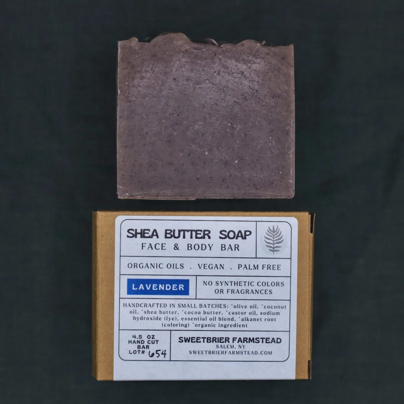 2 bars of Sweetbrier Farmstead Lavender Bar Soap one with label and one without on green background