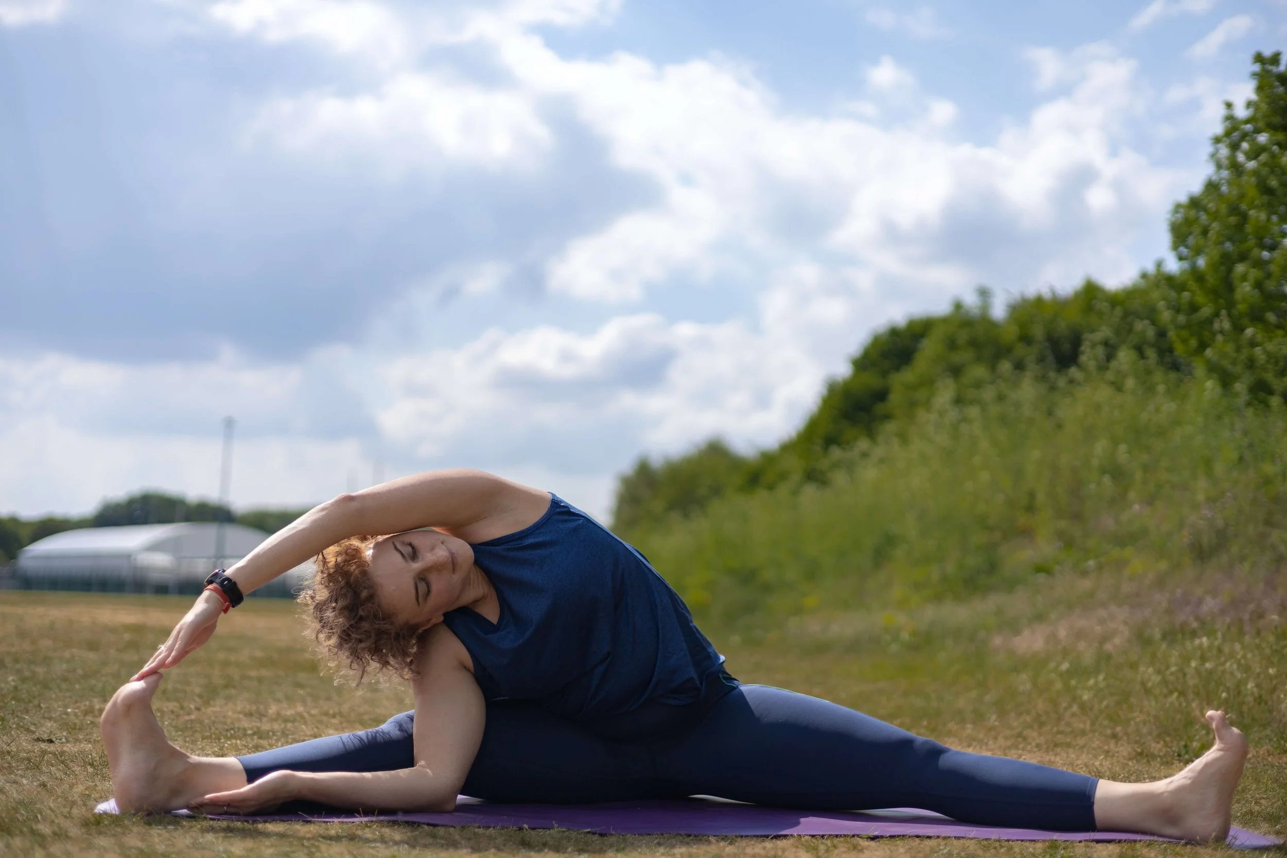 Outdoor yoga portrait with natural light and a relaxed documentary style.