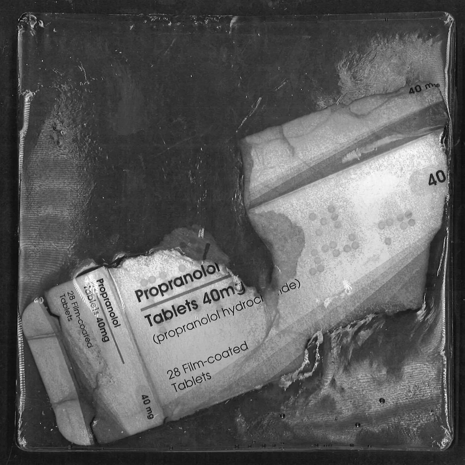 Partially burned pack of Propranolol 40mg tablets, with text 'Propranolol Tablets 40mg (propranolol hydrochloride)' and '28 Film-coated Tablets' visible.