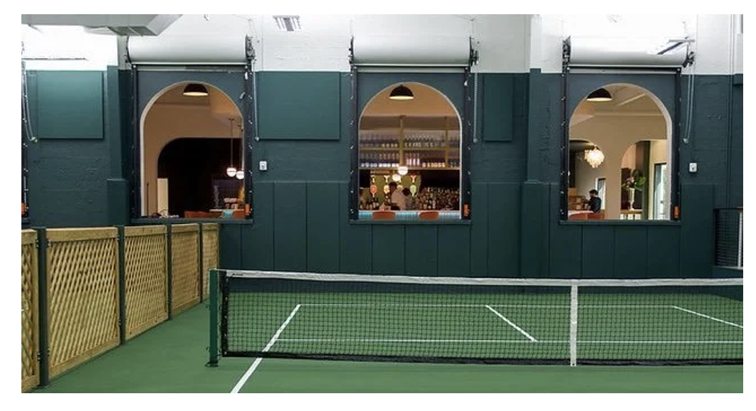 Indoor pickleball court at Athletic bar in downtown St. Petersburg, Florida with seating and social atmosphere