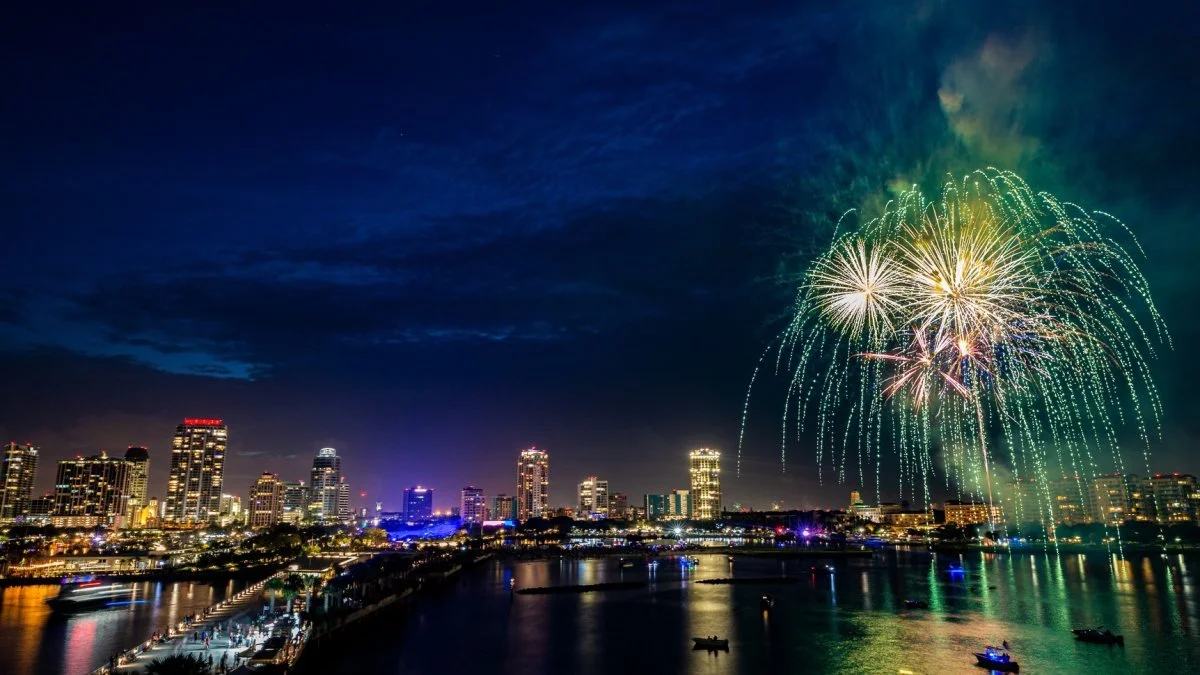 New Year’s Eve fireworks over St. Pete Pier with downtown St. Petersburg Florida skyline reflected on Tampa Bay during NYE celebration