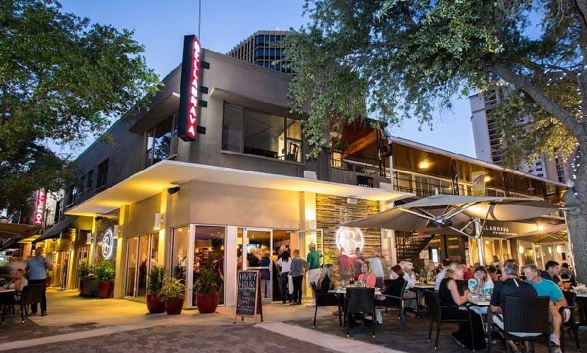 BellaBrava restaurant on Beach Drive in St. Pete with warm evening lighting and guests dining at outdoor tables.