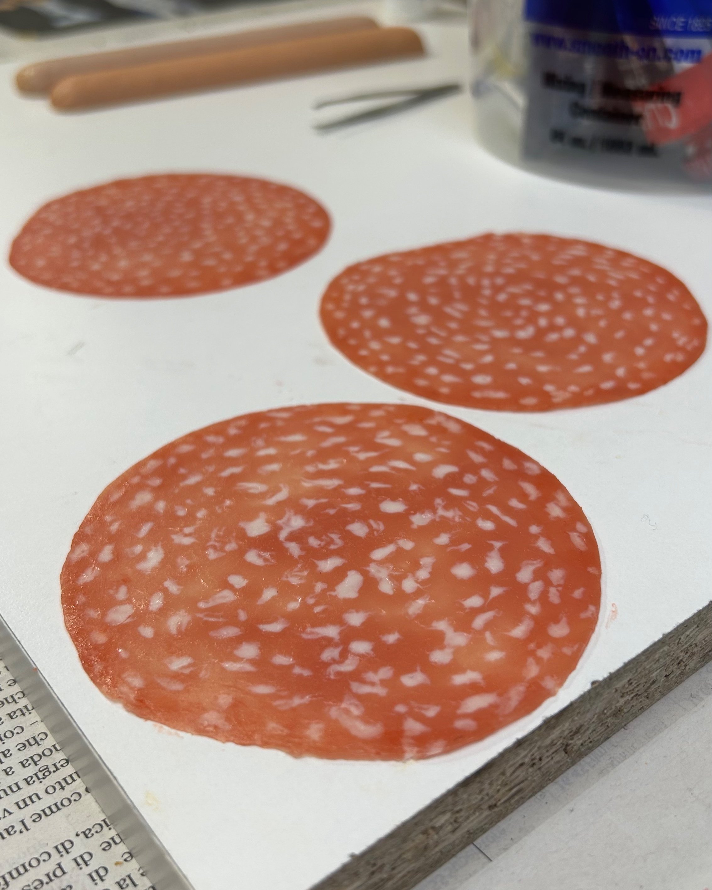 Tre fette di salame Milano finte su un tavolo